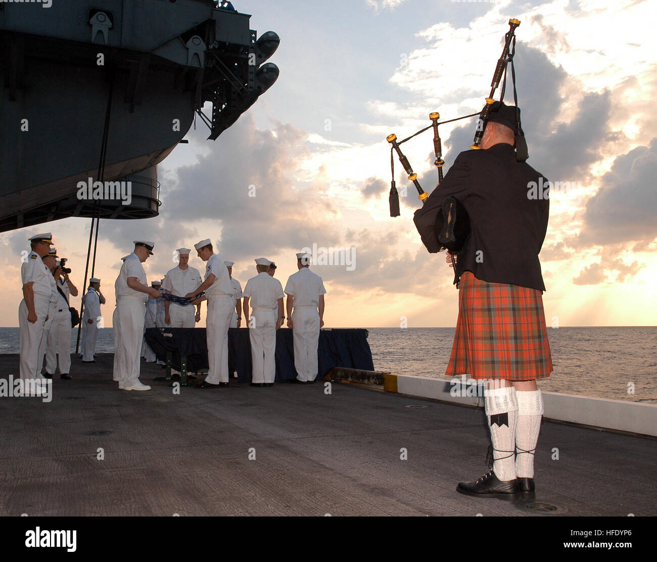 040519-N-0119G-009 Atlantic Ocean (May 19, 2004) - USS Enterprise (CVN 65) combat systems department officer, Cmdr. Mark Sanford plays 'Amazing Grace' on the bag pipes during a Burial at Sea ceremony conducted from one of the ship's aircraft elevators aboard the aircraft carrier USS Enterprise (CVN 65) for Machinist's Mate 3rd Class Nathan Taylor. Enterprise is currently underway conducting Carrier Qualifications in the Atlantic Ocean. For more information on the burial at sea program visit the Navy's web site at: http://www.chinfo.navy.mil/navpalib/questions/burial.html. U.S. Navy photo by Ph Stock Photo