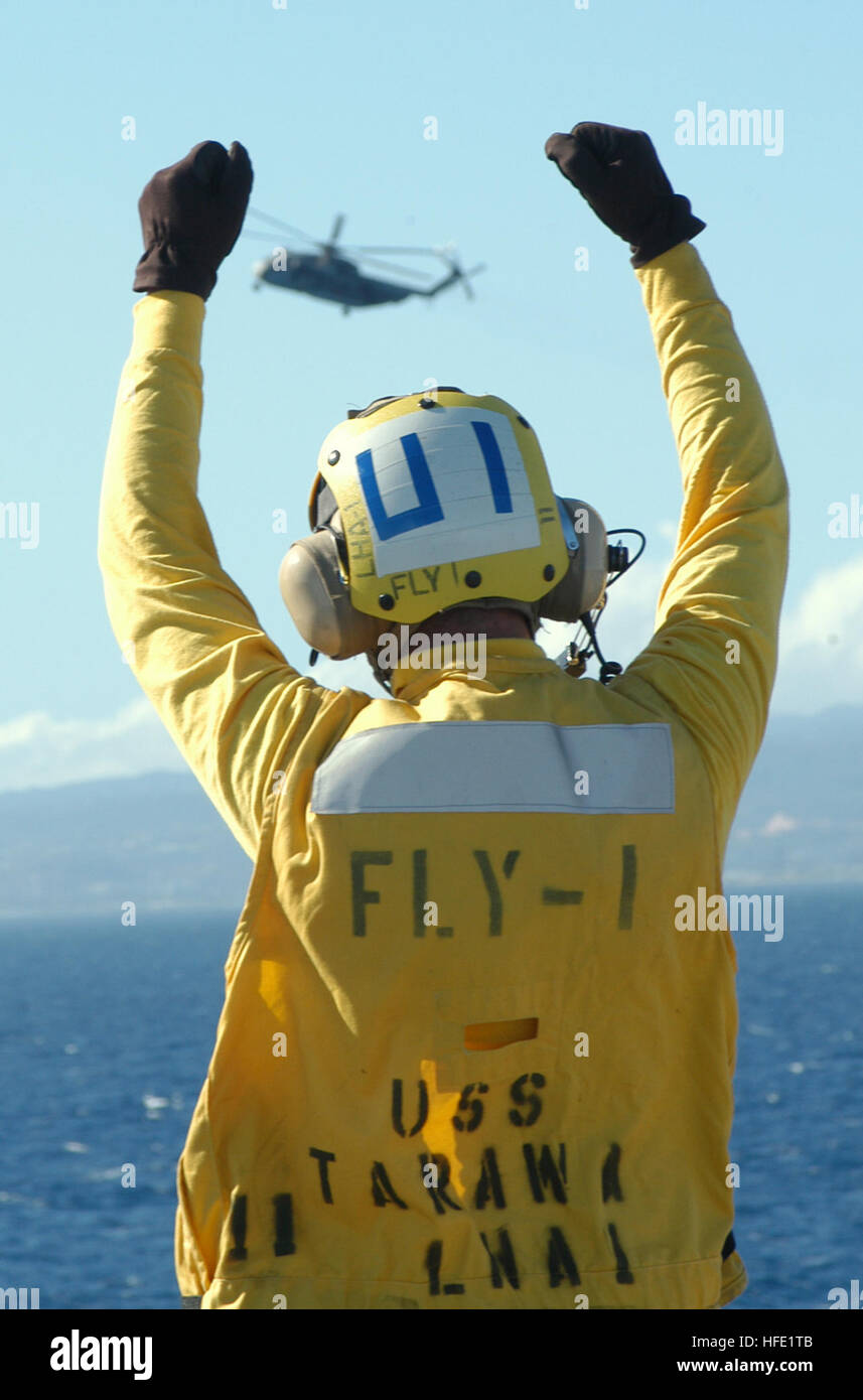 040706-N-4304S-232 Pacific Ocean (July 6, 2004) - Airman Tony Pavlich signals a CH-53D Sea Stallion from Marine Heavy Helicopter Squadron 363 (HMH-363) preparing to land aboard the amphibious assault ship USS Tarawa (LHA 1). Tarawa is one of many U.S. ships participating in exercise Rim of the Pacific (RIMPAC) 2004. RIMPAC is the largest international maritime exercise in the waters around the Hawaiian Islands.  This years exercise includes seven participating nations; Australia, Canada, Chile, Japan, South Korea, the United Kingdom and the United States.  RIMPAC is intended to enhance the tac Stock Photo