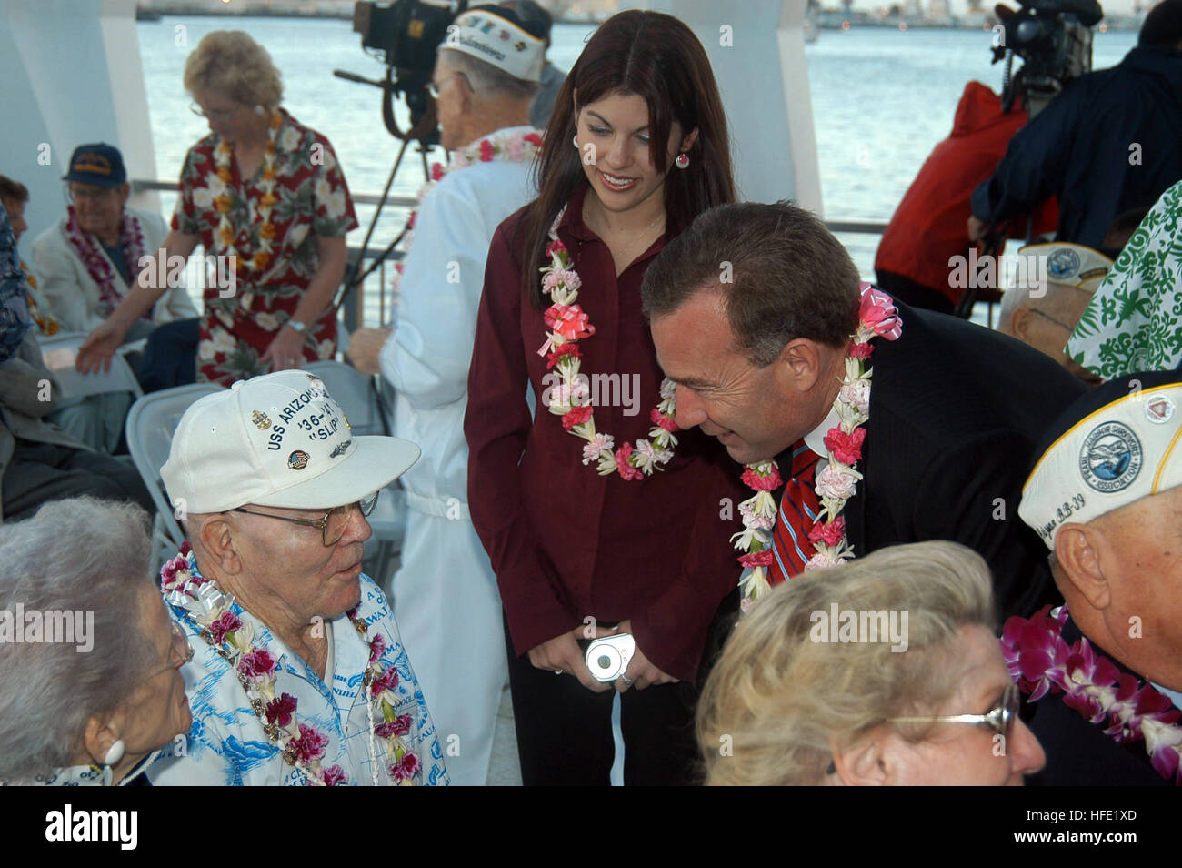 041207-N-6775N-031 Pearl Harbor, Hawaii (Dec. 7, 2004) - Senator Jim Reynolds (R-OK) and his daughter speaks with retired Chief Engineman Charles W. 'Slip' Hailslip about his experiences aboard USS Arizona on the day of the attack on Pearl Harbor. More than 200 distinguished visitors and Pearl Harbor survivors attended the Remembrance Ceremony, which included the Arleigh Burke-class guided missile destroyer USS Chung-Hoon (DDG 93) rendering honors, more than 40 wreath presentations, a 21-gun salute, and a missing man flyover. U.S. Navy photo by Photographer's Mate 2nd Class Justin P. Nesbitt ( Stock Photo
