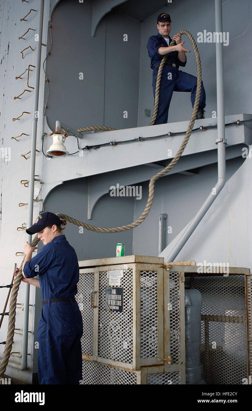 040719-N-1485H-013 Japan (July 19, 2004) - Seaman Maria Garcia, from Lakeland, Minn., and Seaman Adam Rich, from Asheboro, N.C., stow a mooring line aboard USS Kitty Hawk (CV 63), as the ship departs its operating base of Yokosuka, Japan. The Kitty Hawk Strike Group is participating in Summer Pulse 2004, the simultaneous deployment of seven carrier strike groups (CSGs), demonstrating the ability of the Navy to provide credible combat across the globe, in five theaters with other U.S., allied, and coalition military forces. Summer Pulse is the NavyÕs first deployment under its new Fleet Respons Stock Photo