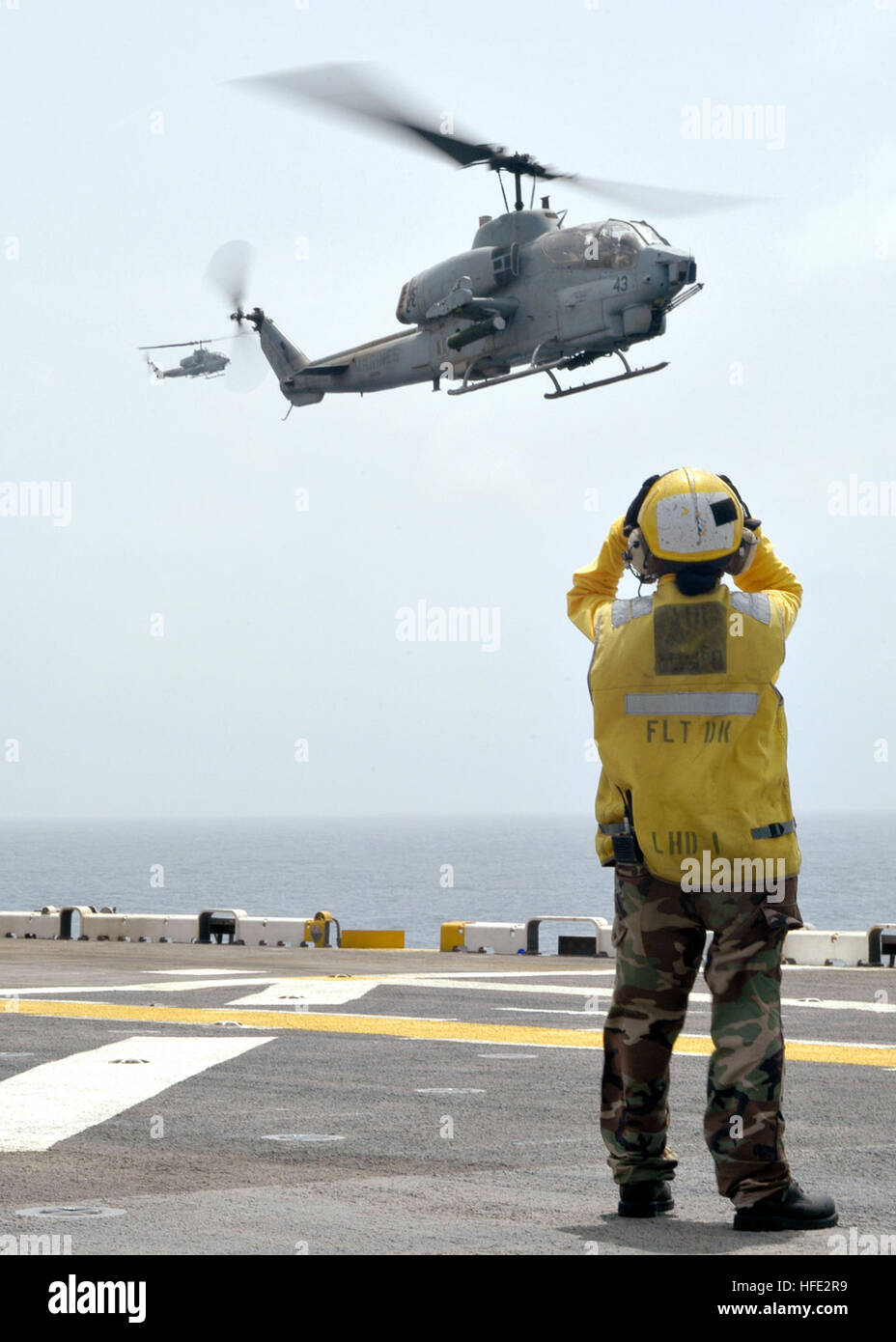 040724-N-6380E-149 Indian Ocean (July 24, 2004) - Aviation BoatswainÕs Mate Airman Marlene M. Flores, a Landing Signal Enlisted (LSE), directs the arrival of an AH-1N Cobra assigned to the ÒFighting GriffinsÓ of Marine Helicopter Medium Squadron Two Six Six (HMM-266) on to the flight deck of the amphibious assault ship USS Wasp (LHD 1). HMM-266 is the Aircraft Combat Element of the 22nd Marine Expeditionary Unit (MEU)(Special Operations Capable) as they return to the flight deck of the amphibious assault ship USS Wasp (LHD 1). The 22nd MEU is part of the Wasp Expeditionary Strike Group two (ES Stock Photo