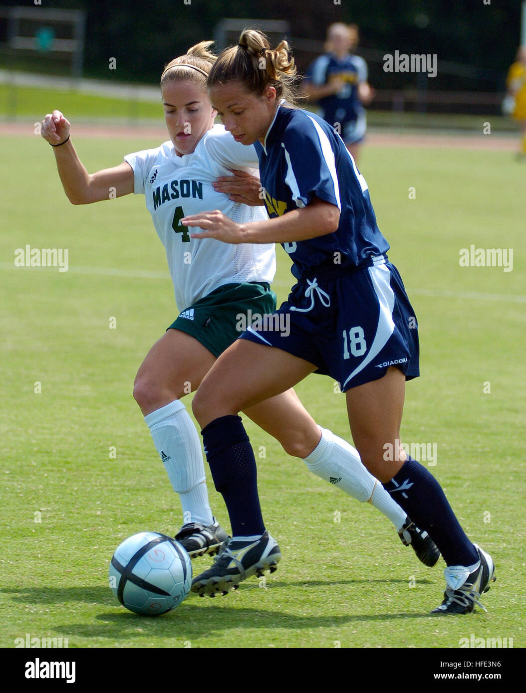 040829-N-9694M-002 Fairfax, Va. (Aug. 29, 2004) - U.S. Naval Academy Midshipman 3rd Class Meggie Curran races to keep the ball away from George Mason University's Danielle McDonald during a regular season soccer match. Sophomore forward Meggie Curran, from Silver Spring, Md., put the Mids on top in the 14th minute when rookie Kari Weniger, St. Petersburg, Fla., crossed the ball to Curran who fired in the shot to the lower left side of the net. Two days after playing the eighth-ranked team in the country, Connecticut, the Navy women's soccer team (0-1-1) battled George Mason (1-0-1) to a 1-1 ti Stock Photo