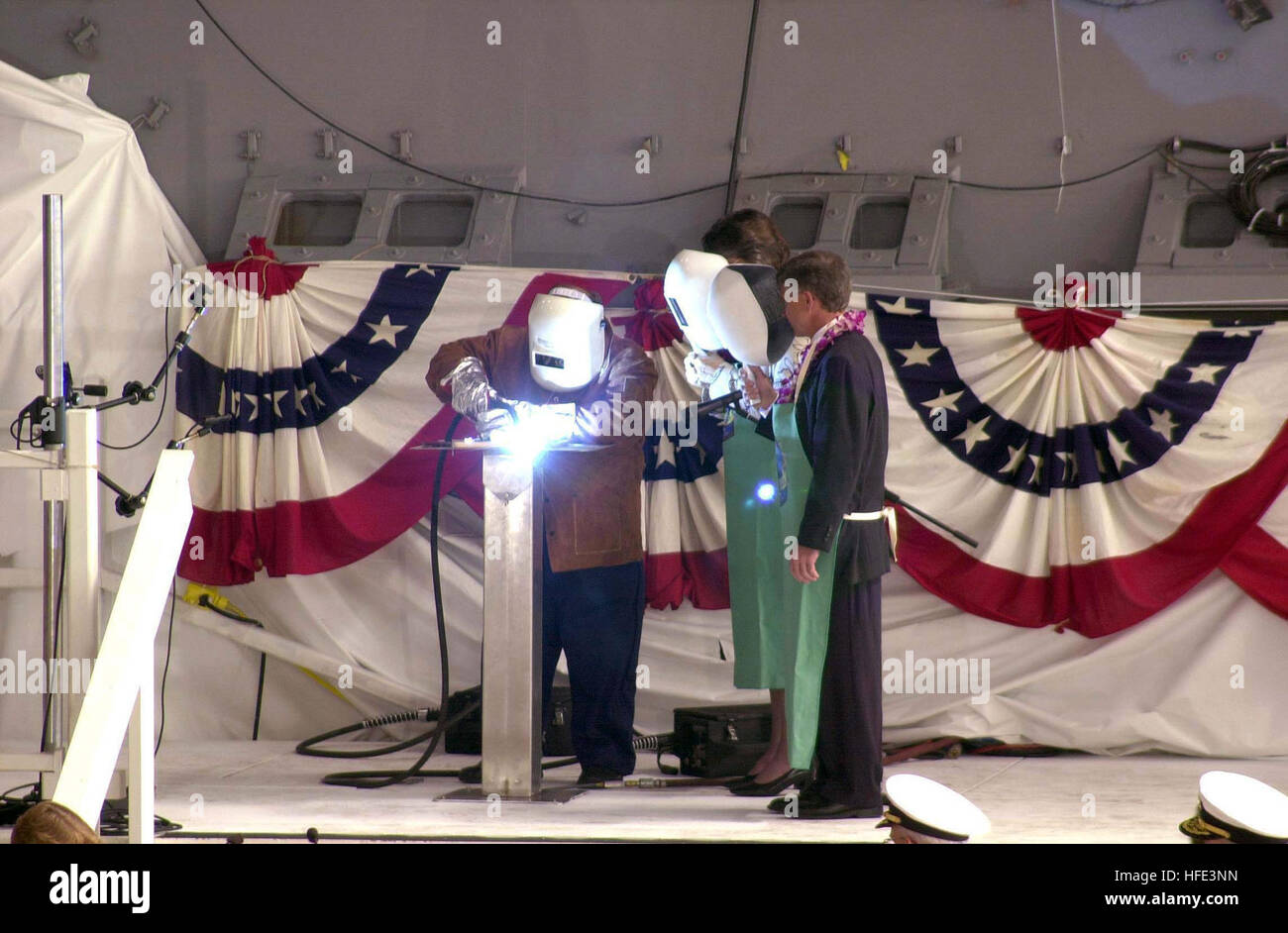 040827-N-1876S-001 North Kingstown, R.I. (Aug. 27, 2004) - John Weiss, left, a welder with General Dynamics Electric Boat (GDEB), welds Hawaii Governor Linda Lingle's initials into a steel plate as Governor Lingle and John P. Casey, President of GDEB, looks on. Lingle, the sponsor of Precommissioning Unit Hawaii (SSN 776), joined several dignitaries at GDEB's Quonset Point facility in North Kingstown, R.I. for the keel laying ceremony of the Navy's third Virginia-class submarine. U.S. Navy photo by Journalist First Class Mark A. Savage (RELEASED) US Navy 040827-N-1876S-001 John Weiss, left, a  Stock Photo