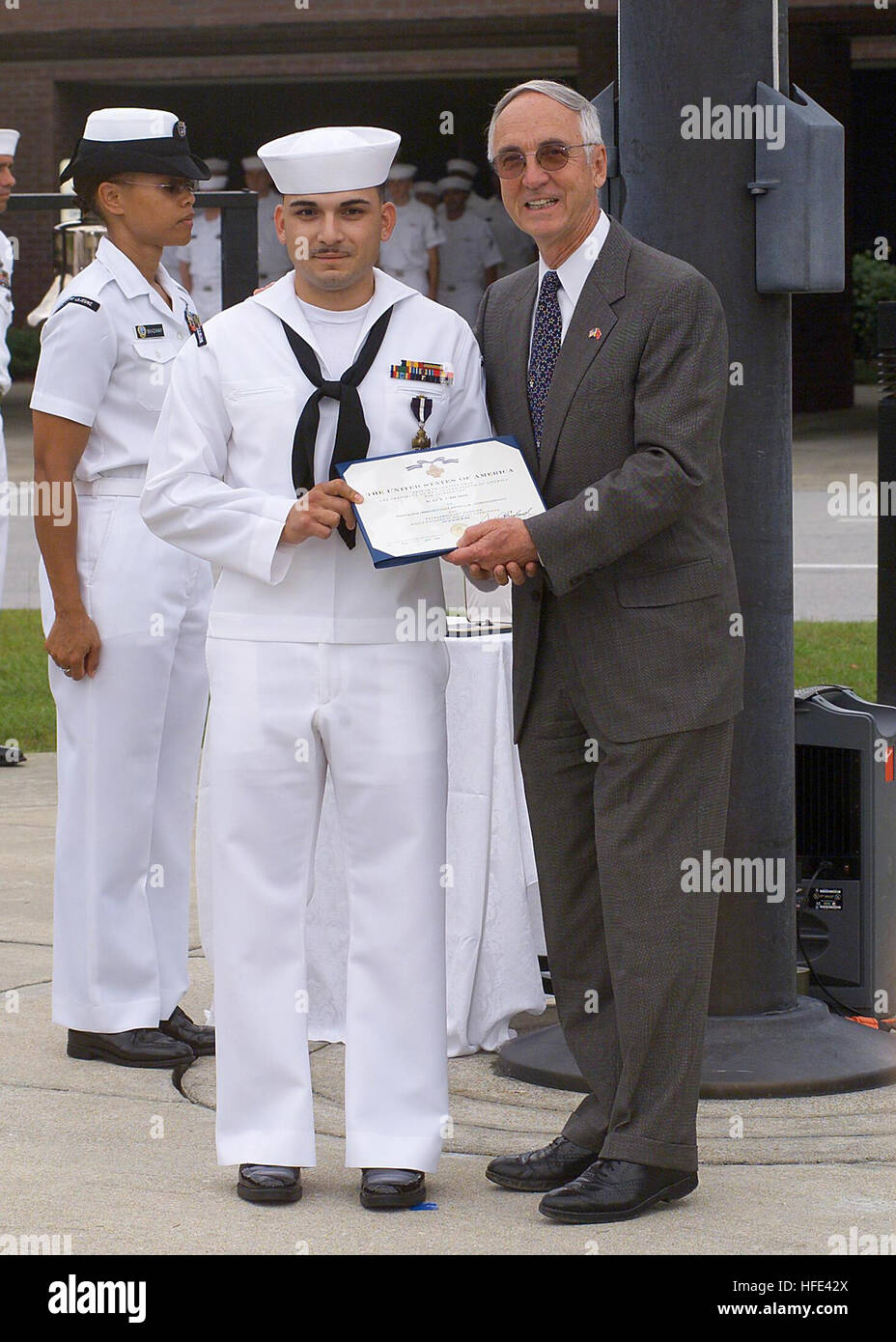 040811-N-0000X-002 Camp Lejeune, N.C. (Aug. 11, 2004) Ð Secretary of the Navy, Gordon R. England presents the Navy Cross to Hospitalman Apprentice Luis E. Fonseca, Jr., for heroism during the battle of An Nasiriyah, Iraq, in March 2003. Under attack and without concern of his own safety, Hospitalman Apprentice Fonseca braved small arms, machine gun, and intense rocket-propelled grenade fire to evacuate wounded Marines from a burning amphibious assault vehicle. He stabilized two casualties with lower limb amputations with tourniquets and administered morphine, while organizing the evacuation of Stock Photo