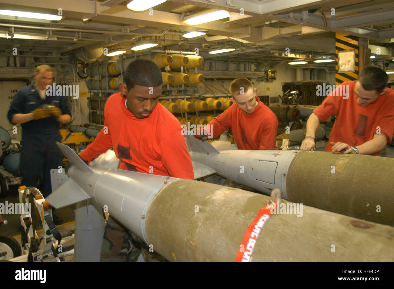 040926-N-2541H-002 Arabian Gulf (Sept. 26, 2004) - Aviation Ordnanceman Airman Charles Robinson of National City, Calif., attaches a conical fin to a MK-83 general-purpose bomb in the forward bomb assembly aboard the conventionally powered aircraft carrier USS John F. Kennedy (CV 67). Kennedy and Carrier Air Wing Seventeen (CVW-17) are operating in the 5th Fleet area of responsibility (AOR) in support of Operation Iraqi Freedom (OIF).  Units attached to the Kennedy Carrier Strike Group (CSG) are working closely with Multi-National Corps-Iraq and Iraqi forces to bring stability to the sovereign Stock Photo