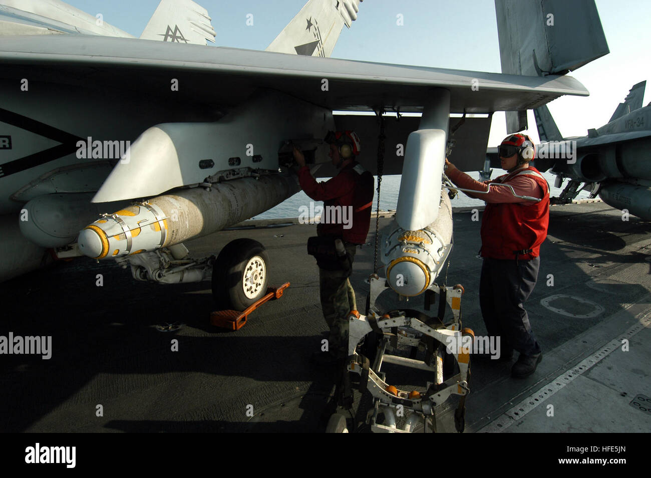 041109-N-8704K-005 Arabian Gulf (Nov. 9, 2004) - Aviation Ordnancemen, assigned to the ÒRampagersÓ of Strike Fighter Squadron Eight Three (VFA-83), finish loading two of the Navy's latest Satellite Guided Bomb, the GBU-38, aboard the conventionally powered aircraft carrier USS John F. Kennedy (CV 67). The GBU-38 is a 500-pound Joint Direct Attack Munition (JDAM) that uses a standard Mk-82 bomb, and was developed for precision bombing in urban warfare. The Joint Direct Attack Munition (JDAM) is a guidance kit that converts existing unguided bombs into precision-guided 'smart' munitions. The tai Stock Photo