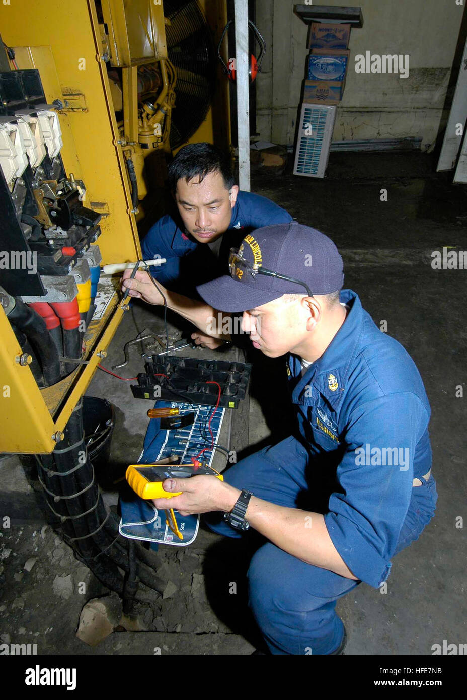 050106-N-9951E-022 Aceh, Sumatra, Indonesia (Jan. 6, 2005) - Chief Electrician's Mate Conrad Capindo, foreground, and Electrician's Mate 2nd Class Alex Taliman, work on the emergency diesel power generator behind the main hospital in Aceh, Sumatra, Indonesia. The hospital was flooded in over four feet of water during the Tsunami that struck December 26, 2004, which shorted all electrical power to the hospital. Small generators are temporarily being used to provide electricity to some of the vital systems the hospital needs to care for patients. The USS Abraham Lincoln (CVN 72) Carrier Strike G Stock Photo