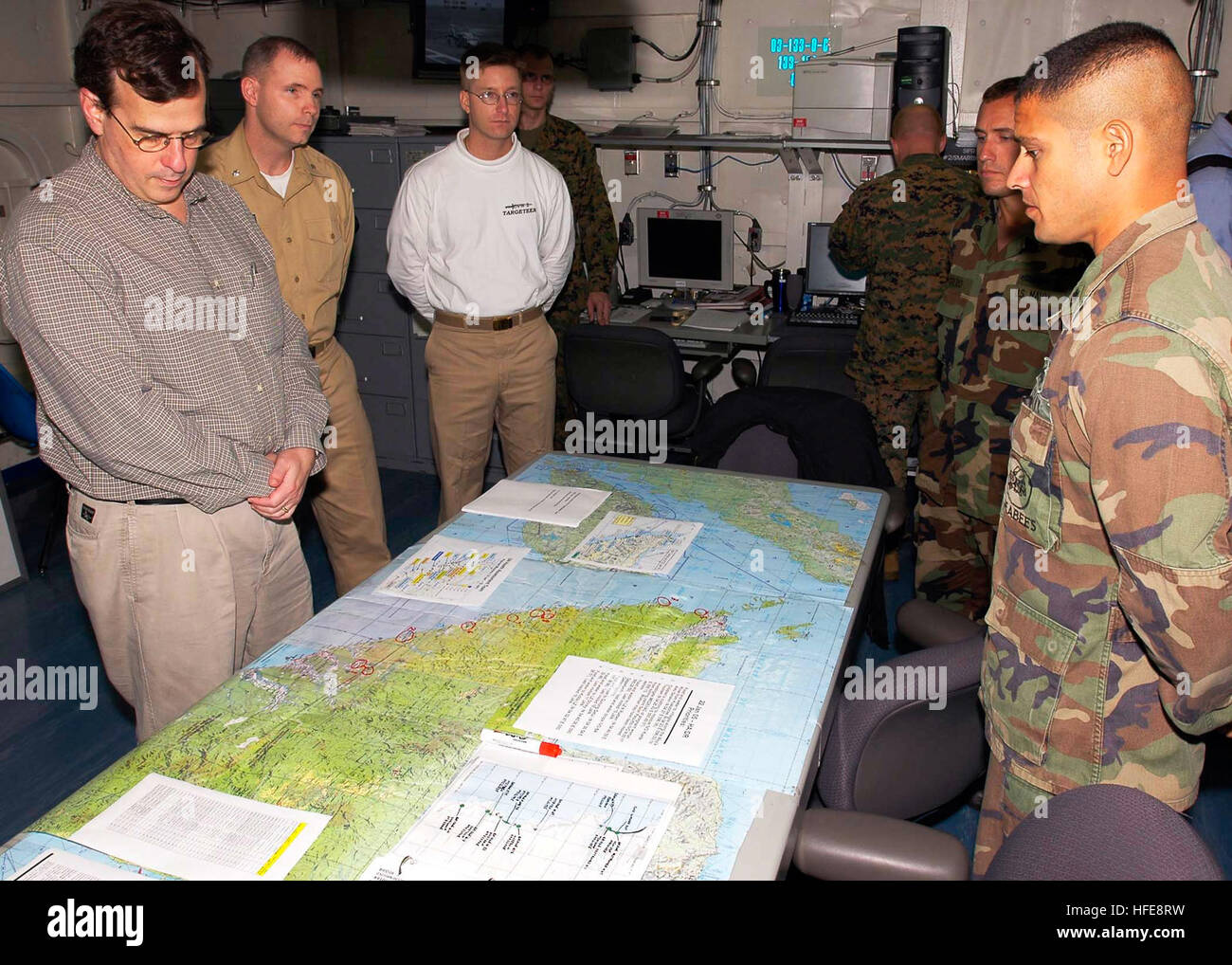 050122-N-6074Y-005 Indian Ocean (Jan. 22, 2005) - U.S. Ambassador to Singapore, the Honorable Frank Lavin, left, listens to a logistics brief from a field doctor in the carrier intelligence center (CVIC) as the intelligence officer, Cmdr. Stephen Roberts looks on. Helicopters and Sailors assigned to the USS Abraham Lincoln (CVN 72) Carrier Strike Group are supporting Operation Unified Assistance, the humanitarian operation effort in the wake of the Tsunami that struck South East Asia. The Abraham Lincoln Carrier Strike Group is currently operating in the Indian Ocean off the waters of Indonesi Stock Photo