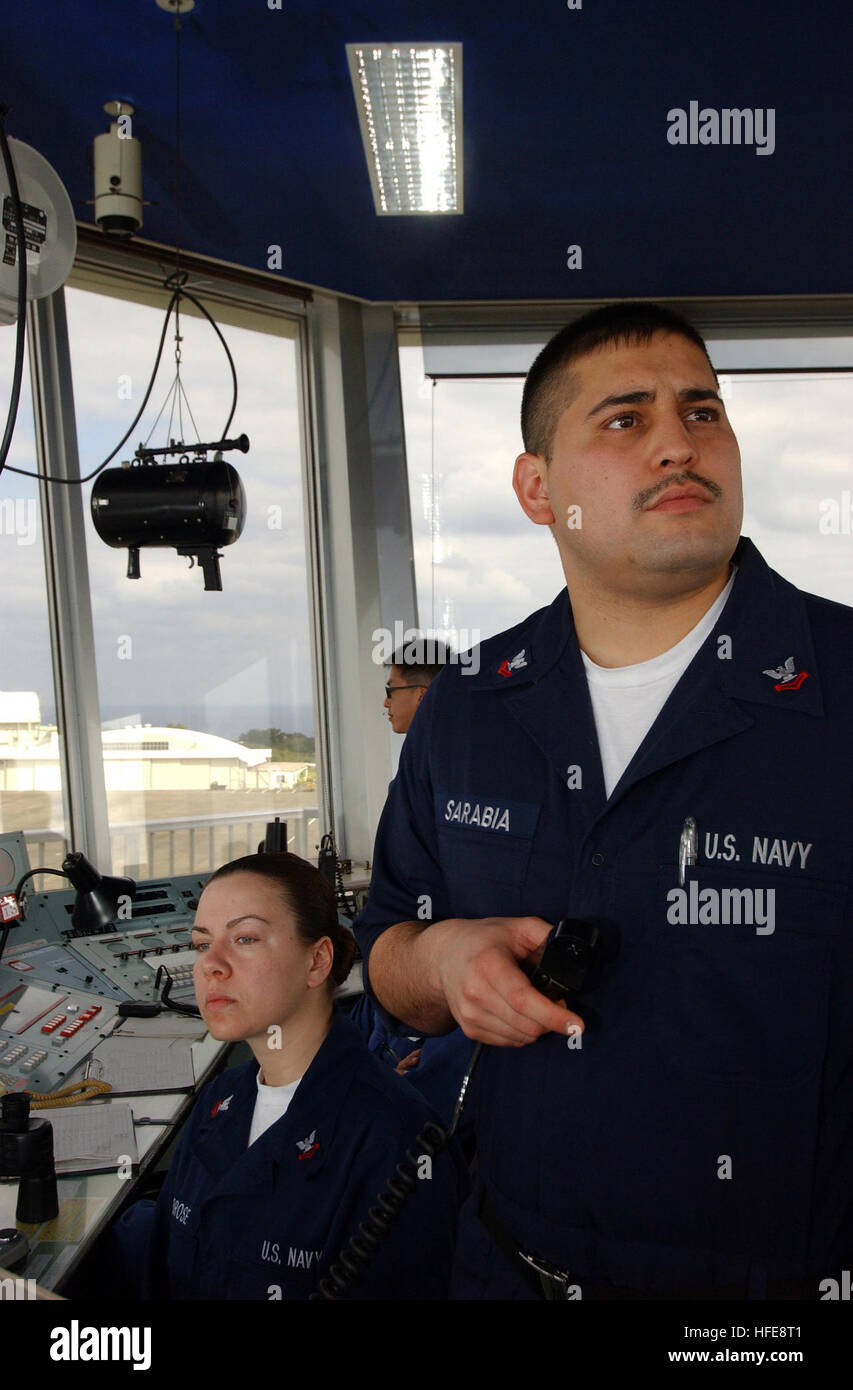050122-N-3503M-002 Iwo Jima Air Base, Japan (Jan.22, 2005)- Air Traffic Controller 2nd Class Rigo Sarabia and Air Traffic Controller 2nd class M.J. Ambrose watch the flight patterns out from the controle tower on board Iwo Jima airbase. Both sailors, with Carrier Air Traffic Control Center (CATCC) aboard USS Kitty Hawk (CV 63), detached to Iwo Jima in support for Carrier Airwing FIVE carrier qualifications.  Official U.S. Navy Photograph by Photographer's Mate Third Class Air Warfare Joshua Millage US Navy 050122-N-3503M-002 Air Traffic Controller 2nd Class Rigo Sarabia, right, and Air Traffic Stock Photo
