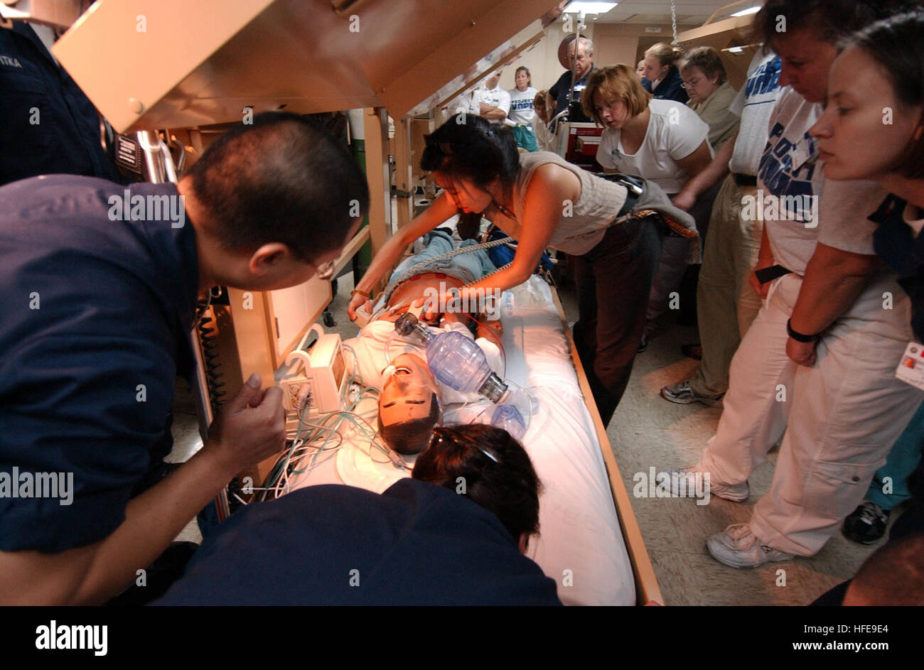 050205-N-8796S-005 Indian Ocean (Feb. 5, 2005) - U.S. Navy Hospital Corpsmen and members of the non-governmental organization 'Project Hope', stand by as Dr. Waichi Wong, a 'Project Hope' volunteer, defibrillates a simulated patient during a code blue drill aboard the Military Sealift Command (MSC) hospital ship USNS Mercy (T-AH 19). The drill allowed military members and 'Project Hope' medical personnel an opportunity to work with and learn from one another. Mercy has been forward deployed to assist in humanitarian aid efforts currently in progress. Mercy will serve as an enabling platform to Stock Photo