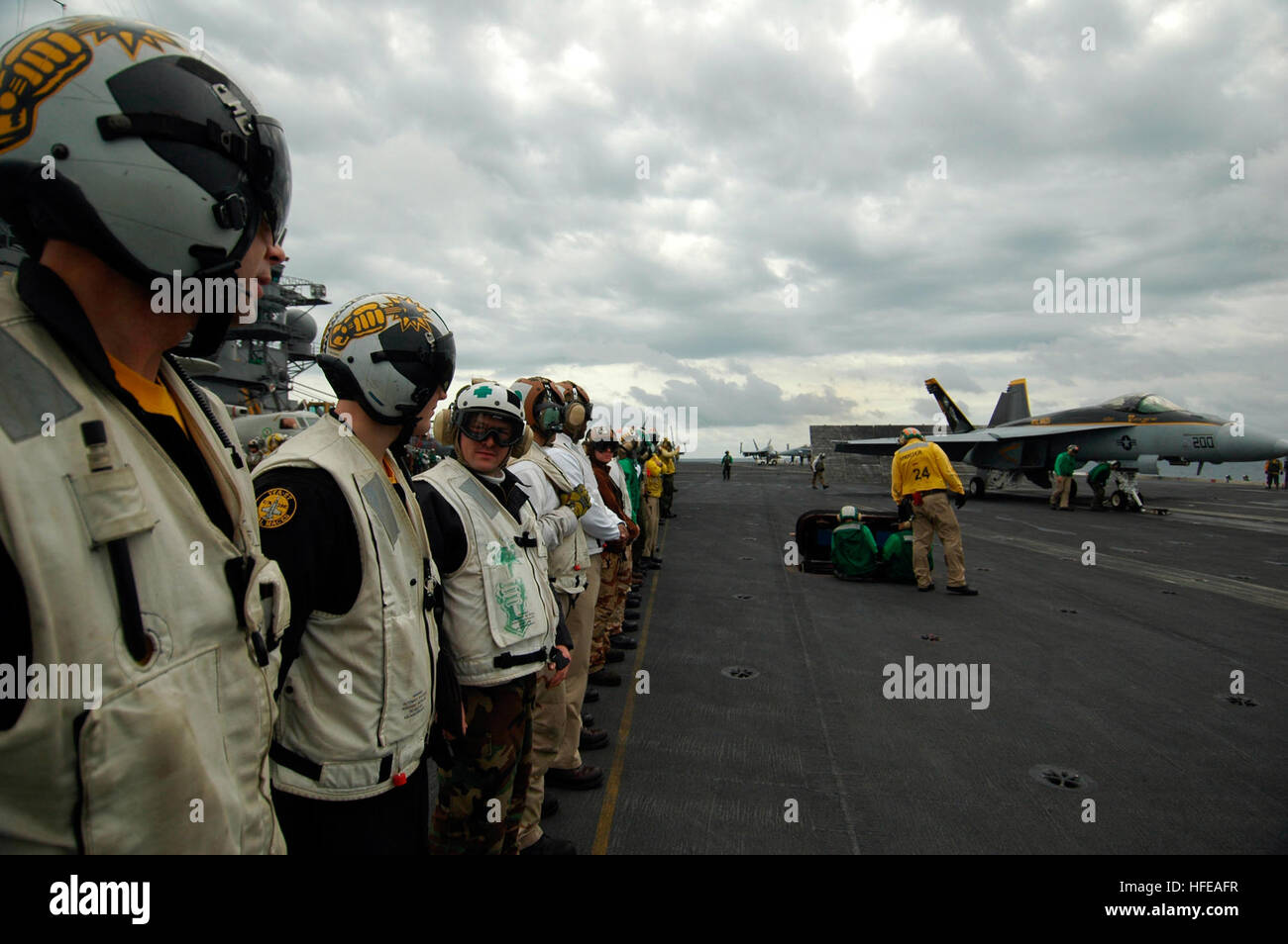 050303-N-5781F-039 Pacific Ocean (Mar. 3, 2005) - The officers and Sailors, assigned to the ÒRoyal MacesÓ of Strike Fighter Squadron Two Seven (VFA-27), line up on the flight deck aboard USS Kitty Hawk (CV 63) to watch their outgoing squadron commanding officer, Cmdr. James Bynum, catapult off the flight deck during a fly-by change of command.  Cmdr. Kevin Mannix, VFA-27's former executive officer, took command of the squadron during the fly-by. Currently under way in the 7th Fleet area of responsibility (AOR), Kitty Hawk demonstrates power projection and sea control as the U.S. Navy's only pe Stock Photo