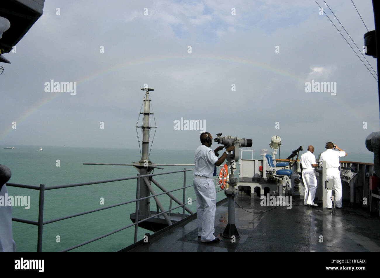 050307-N-4649C-031 Changi Naval Base, Singapore (Mar. 7, 2005) - A rainbow shines over the command ship USS Blue Ridge (LCC 19) as she pulls into Changi Naval Base, Singapore. Blue Ridge, the flagship of Commander, U.S. Seventh Fleet, is visiting Singapore during a routine port visit.  While in Singapore, the Yokosuka, Japan-based ship's approximately 1,000 Sailors, Marines, and staff personnel will enjoy recreational activities, participate in community service projects, and learn more about the Singapore culture.  U.S. Navy Photo by Photographer's Mate 2nd Class Chantel M. Clayton (RELEASED) Stock Photo
