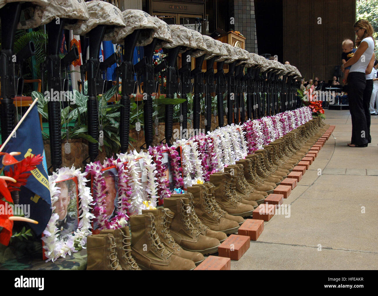 050307-N-3019M-003 Pearl Harbor, Hawaii (Mar. 7, 2005) - A family member reflects in front of a ceremonial formation of U.S. Marine Corps infantry equipment during the First Battalion, Third MarineÕs Memorial Service at the Hawaii State Capitol Building in Pearl Harbor, Hawaii. The memorial honored the 27 Marines and one Sailor who died in a helicopter crash near Ar Rutbah, Iraq on Jan. 26, 2005. The memorial service included remarks by Governor Linda Lingle (R-HI) and Commander, U.S. Marine Forces, Pacific, Lt. Gen. Wallace C. Gregson Jr, a two-bell ceremony and a rifle volley by the Marine C Stock Photo