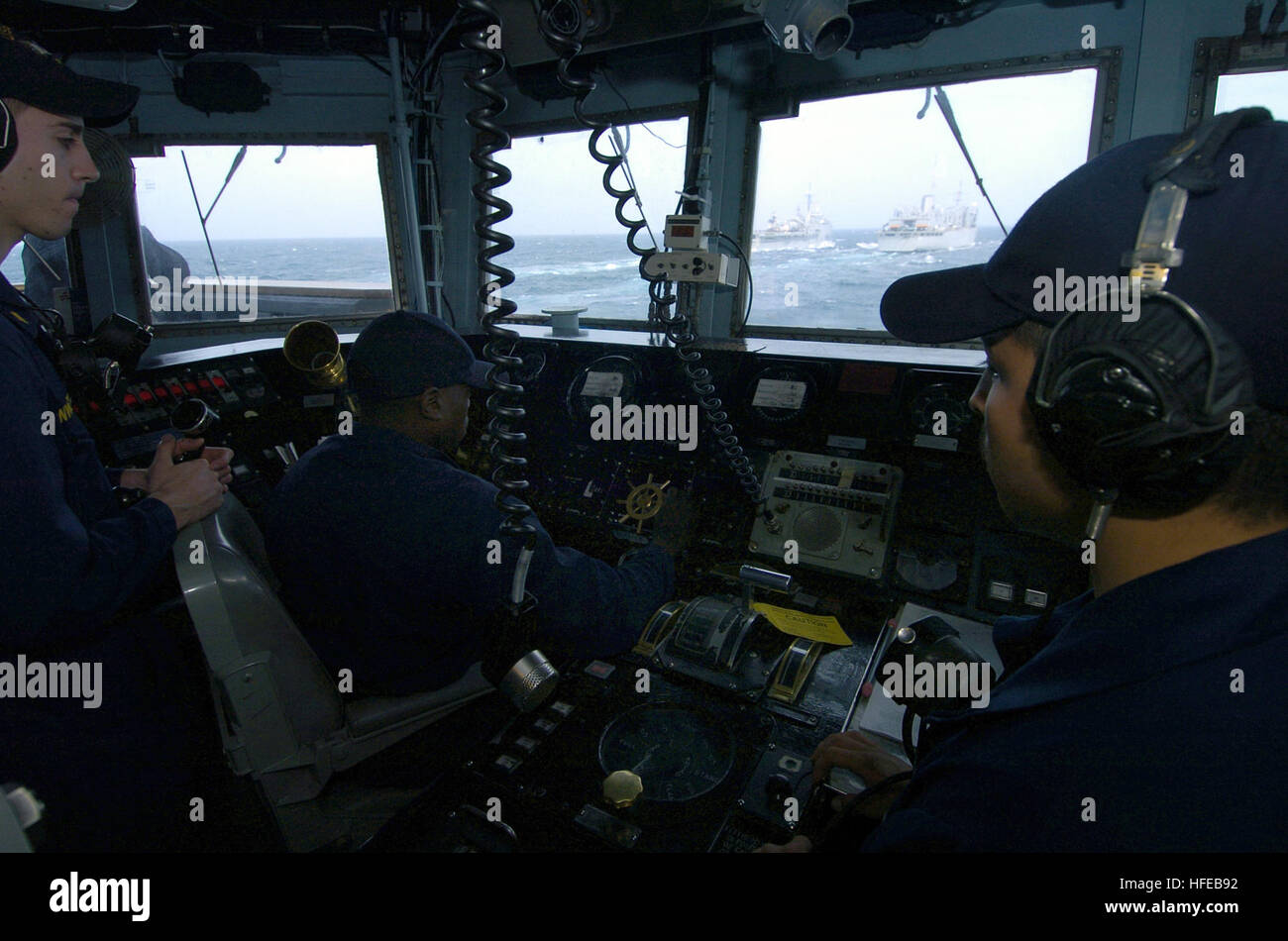050324-N-6932B-016 Persian Gulf (Mar. 24, 2005) - Lee Helmsman, Seaman Christopher Herrera and Helmsman, Seaman Donte Tidwell, both assigned to the guided missile frigate USS Thach (FFG 43), control the ships approach to the fast combat support ship USS Camden (AOE 2) and the amphibious transport dock ship USS Duluth (LPD 6). The three ships will be conducting simultaneous under-way replenishment operations. Thach and Duluth are currently participating in exercise Arabian Gauntlet 2005. Arabian Gauntlet is a multi-lateral surface, air and mine countermeasure exercise designed to practice marit Stock Photo
