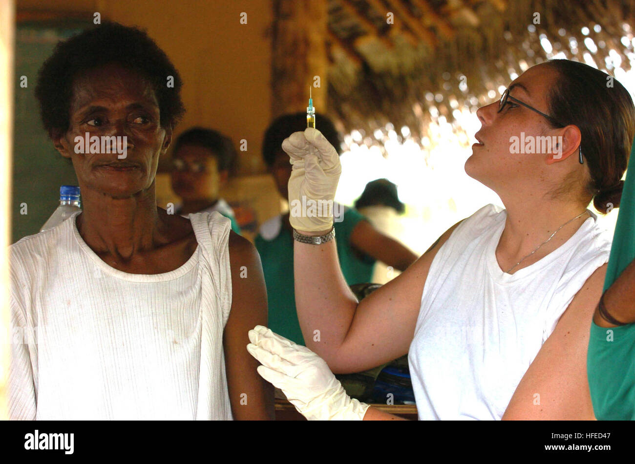 050518-N-1485H-006 Potts Dam, Papua New Guinea (May 18, 2005) Ð Hospitalman Jessica Mayer of Mariss, Ill., preps a syringe filled with measles, mumps and rubella vaccination before injecting a local woman the local village of Potts Dam. The Military Sealift Command (MSC) hospital ship USNS Mercy (T-AH 19) and the MSC combat stores ship USNS Niagara Falls (T-AFS 3) are currently station off the coast of Papua New Guinea to provide humanitarian assistance and focused medical care to the residents affected by a volcano eruption in the area. Navy photo by Photographer's Mate 3rd Class Lamel J. Hin Stock Photo
