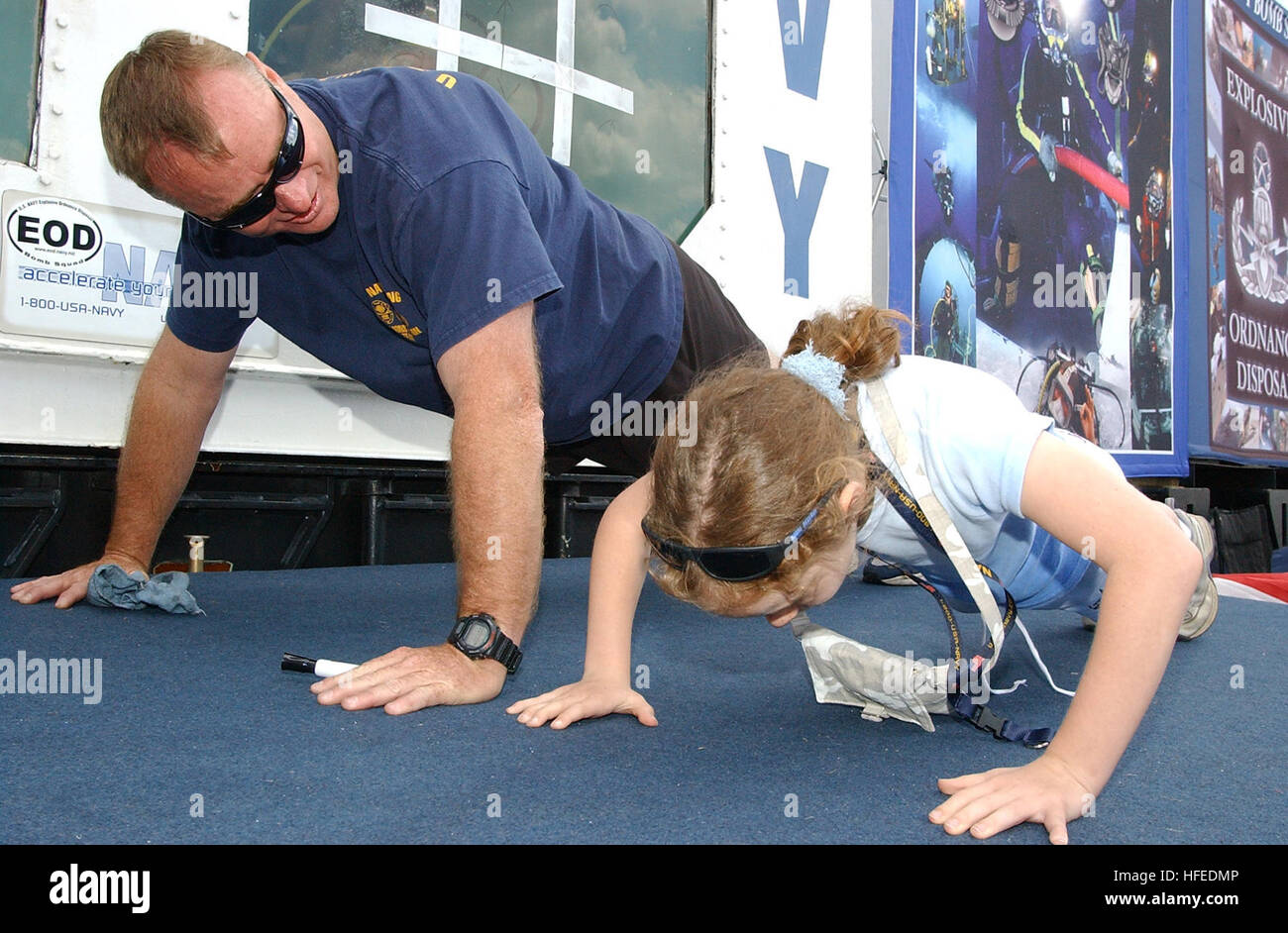 050529-N-4729H-109 Philadelphia, Pa. (May 29, 2005) - Senior Chief Aviation Ordnanceman Ron Mitchell, a recruiter for the Navy Explosive Ordnance Disposal (EOD) community, shows a young fan how to do a Navy push-up at the Naval Air Station Willow Grove Joint Reserve Base air show. The EOD display featured a dive tank with a diver inside, who played tic-tac-toe with the children. More than half a million spectators came to the show, which also featured the U.S. Navy Flight Demonstration Team, the ÒBlue AngelsÓ, F/A-18 simulator rides and many other military and civilian static displays. U.S. Na Stock Photo