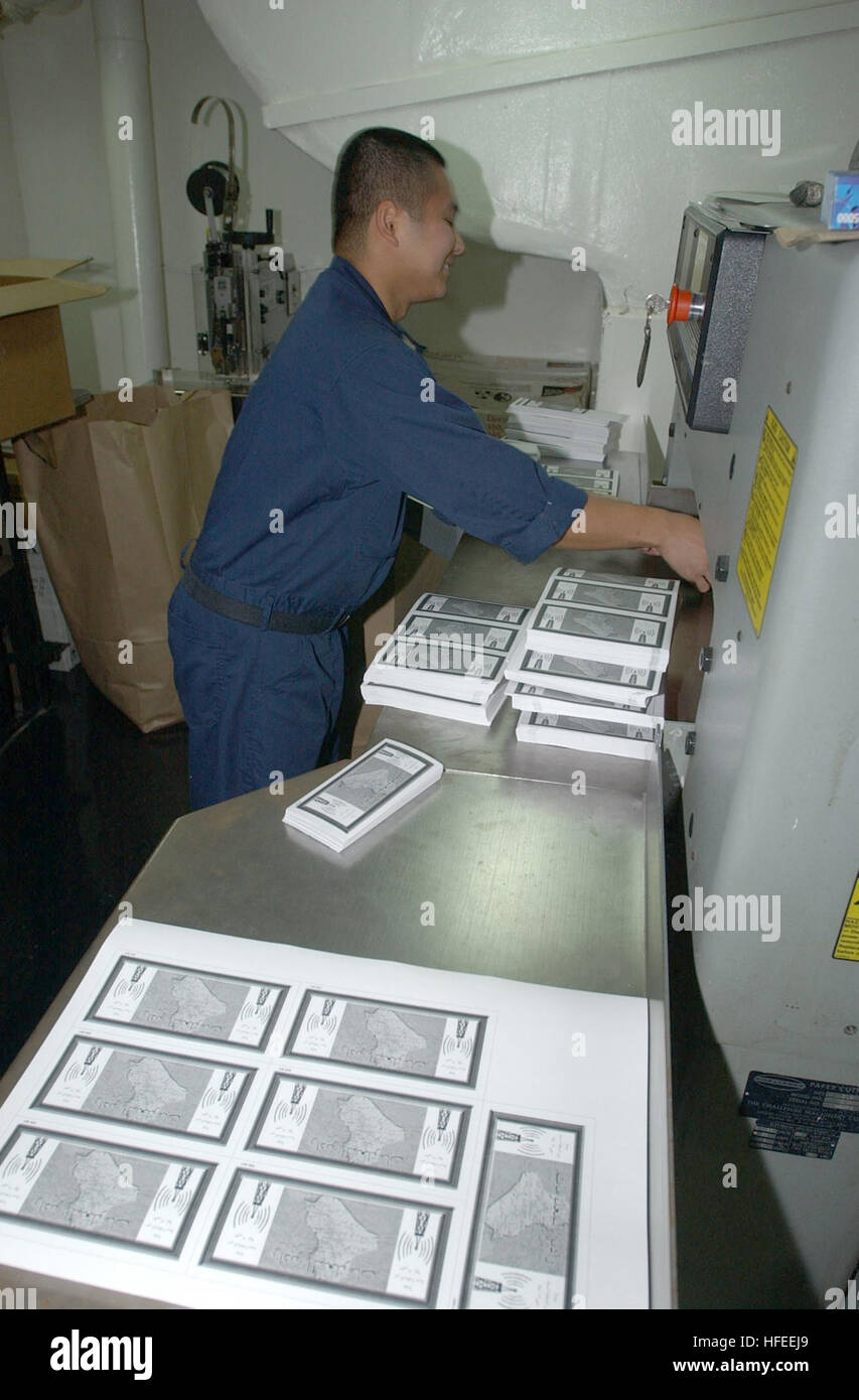 021230-N-4655M-001 At sea aboard USS Constellation (CV 64) Dec. 30, 2002 -- Lithographer 2nd Class Michael Gomez from Guam prepares leaflets that will be dropped over Iraq.  This is the first time ever that leaflets have been printed on a U.S. Navy ship and then used operationally.  U.S. planes patrolling the no-fly zones have begun dropping leaflets encouraging Iraqis to listen for news broadcasts on special radio channels.  The leaflets also mention not to shoot at coalition aircraft.  Constellation is on a regularly scheduled six-month deployment conducting combat missions in support of Ope Stock Photo