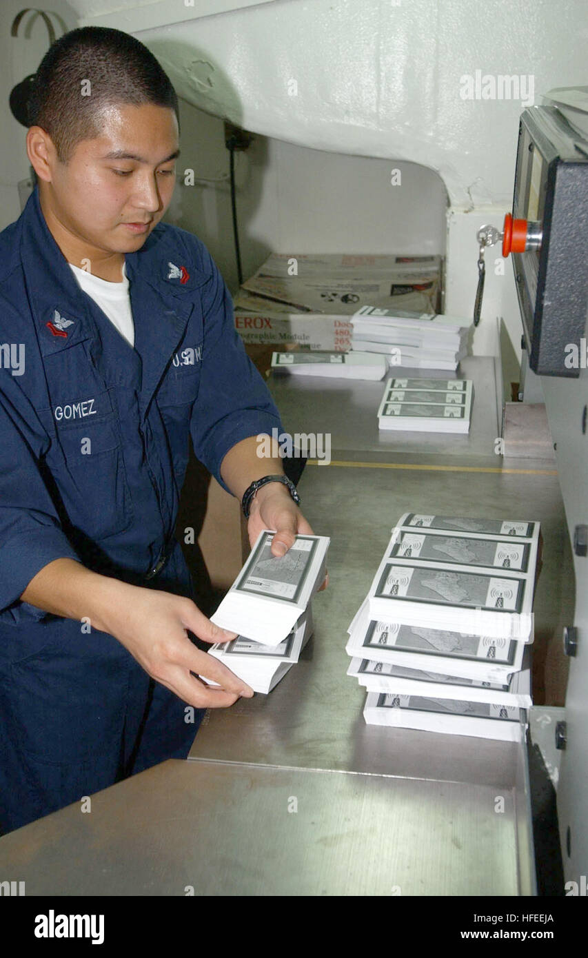 021230-N-4655M-003 At sea aboard USS Constellation (CV 64) Dec. 30, 2002 -- Lithographer 2nd Class Michael Gomez from Guam prepares leaflets that will be dropped over Iraq.  This is the first time ever that leaflets have been printed on a U.S. Navy ship and then used operationally.  U.S. planes patrolling the no-fly zones have begun dropping leaflets encouraging Iraqis to listen for news broadcasts on special radio channels.  The leaflets also mention not to shoot at coalition aircraft.  Constellation is on a regularly scheduled six-month deployment conducting combat missions in support of Ope Stock Photo