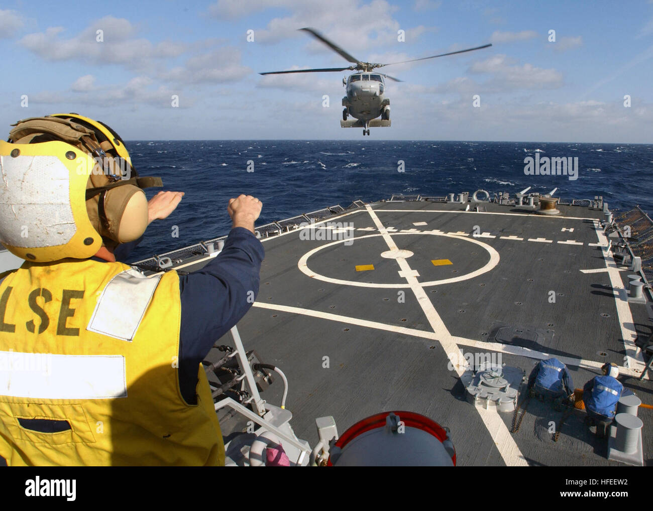 030113-N-3235P-503 At sea aboard USS Donald Cook (DDG 75) Jan. 13, 2003 -- BoatswainÕs Mate 3rd Class Randal S. Davis directs an SH-60 ÒSea HawkÓ helicopter onto the shipÕs flight deck.  The Donald Cook is currently on a regularly scheduled six-month deployment conducting missions in support of Operation Enduring Freedom.  U.S. Navy photo by Photographer's Mate 1st Class Michael W. Pendergrass.  (RELEASED) US Navy 030113-N-3235P-503 Boatswain%%5Ersquo,s Mate 3rd Class Randal S. Davis directs an SH-60 Stock Photo