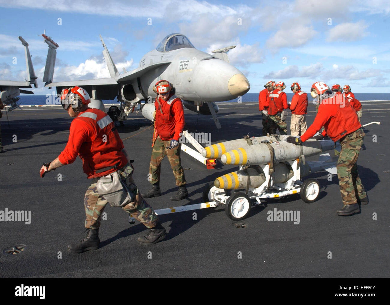 030116-N-6895M-509,510 At sea aboard USS Theodore Roosevelt (CVN-71) Jan. 16, 2003 -- Aviation Ordnancemen assigned to the ÒHuntersÓ of Strike Fighter Squadron Two Zero One (VFA-201) load  bombs under the wing of a F/A-18 ÒHornetÓ on the shipÕs flight deck.  Roosevelt and her embarked Carrier Air Wing Eight (CVW-8) are currently underway conducting training missions in the Atlantic Ocean. U.S. Navy photo by PhotographerÕs Mate 2nd Class James K. McNeil.  (RELEASED) US Navy 030116-N-6895M-509 Aviation Ordnancemen assigned to the Hunters load bombs under the wing of a F-A-18 Stock Photo