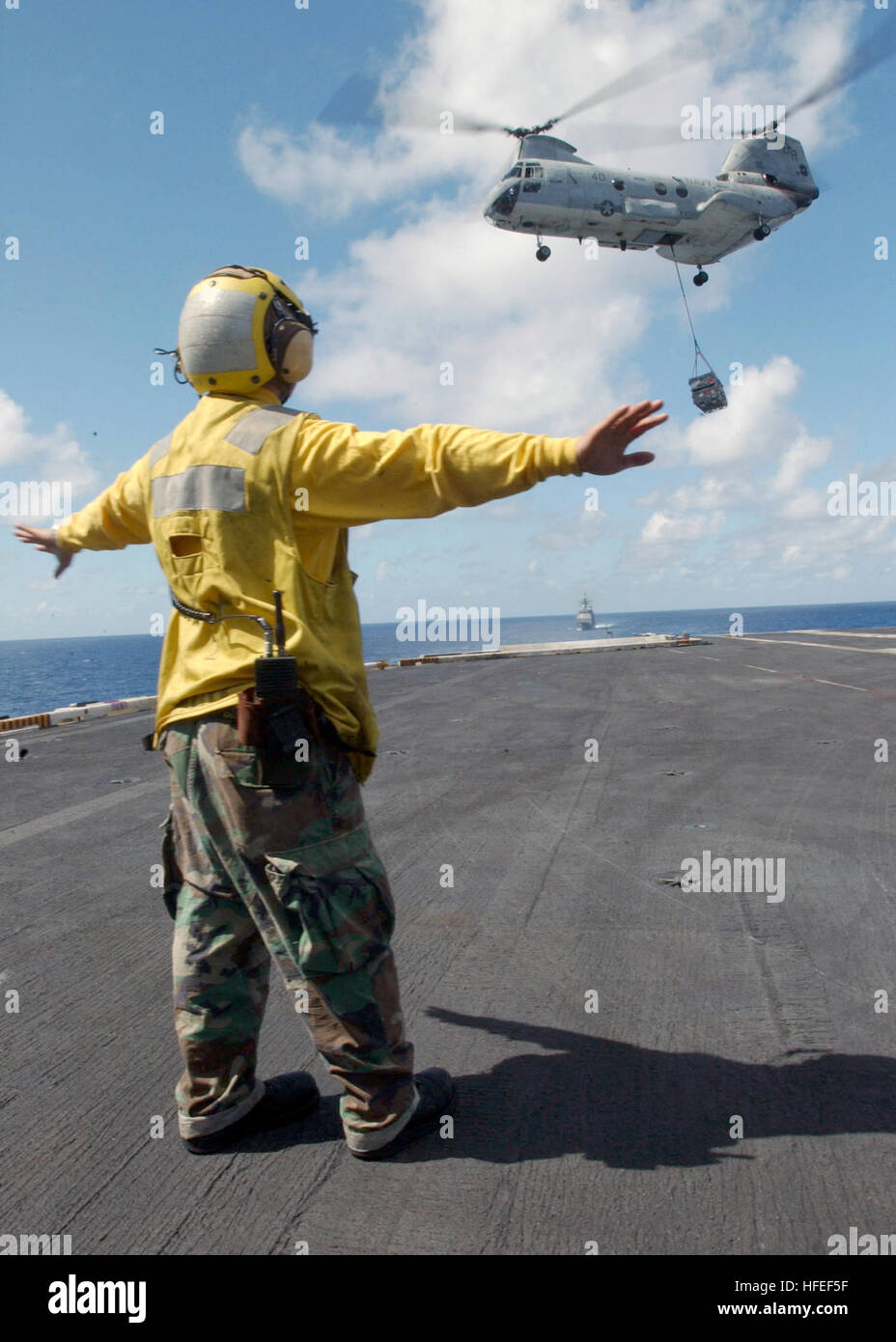 030122-N-6895M-508 At sea aboard USS Theodore Roosevelt (CVN 71) Jan. 22, 2003 -- An Aviation Boatswain's Mate directs a CH-46 ÒSea KnightÓ helicopter as it prepares to place ordnance on the shipÕs flight deck during a Vertical Replenishment at Sea (VERTREP) with the Military Sealift Command ship USNS Arctic (T-AOE 8).  Roosevelt is conducting training exercises in the Caribbean Sea, while preparing for deployment to the central command area of responsibility.  U.S. Navy photo by PhotographerÕs Mate 2nd Class James K. McNeil.  (RELEASED) US Navy 030122-N-6895M-508 Aviation Boatswain's Mate dir Stock Photo