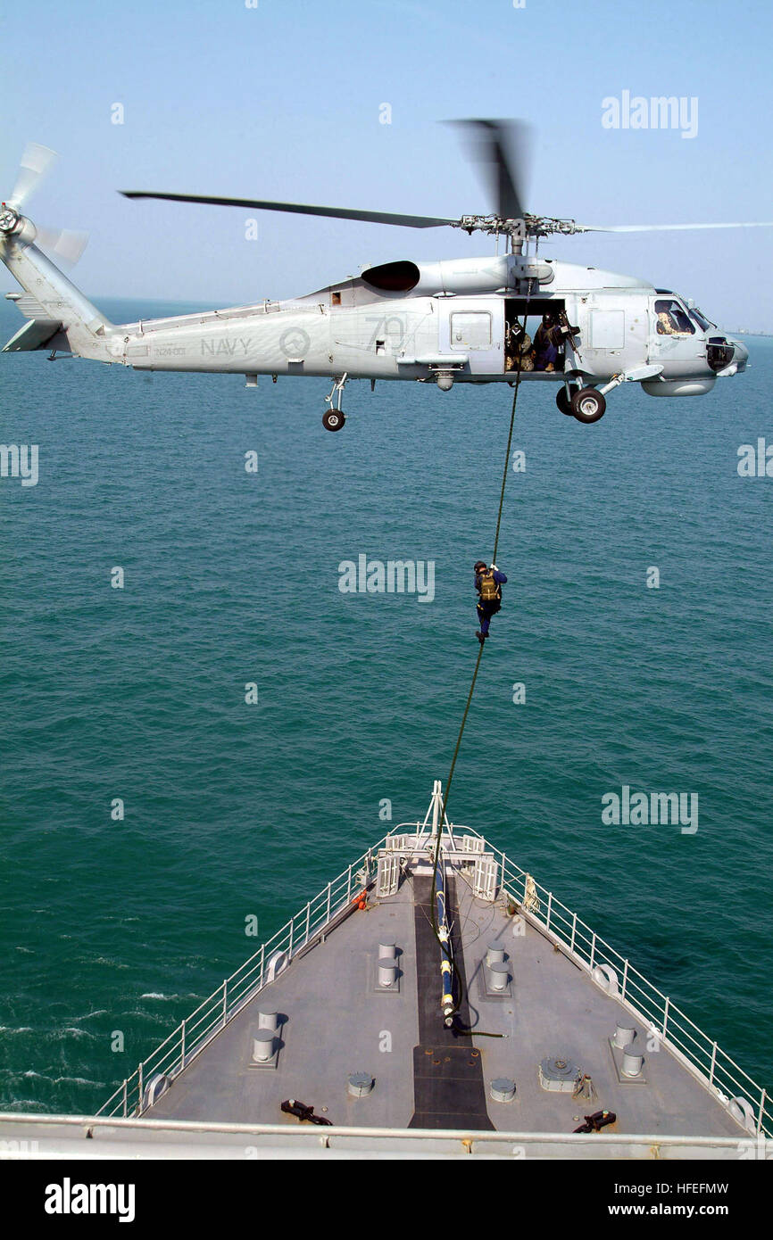 041104-N-4772B-115 Arabian Gulf (Nov. 04, 2004) Ð Boarding team members from the Royal Australian guided missile frigate HMAS Adelaide (FFG 01) conduct a Òfast ropeÓ exercise from an Australian S-70B-2 Seahawk, onto the flight deck of the U.S. NavyÕs amphibious dock landing ship USS Harpers Ferry (LSD 49). Harpers Ferry is part of Expeditionary Strike Group Three (ESG-3) and is currently deployed to the North Arabian Gulf in support of Operation Iraqi Freedom (OIF). U.S. Navy photo by Journalist 2nd Class Brian P. Biller (RELEASED) US Navy 041104-N-4772B-115 Boarding team members from the Roya Stock Photo