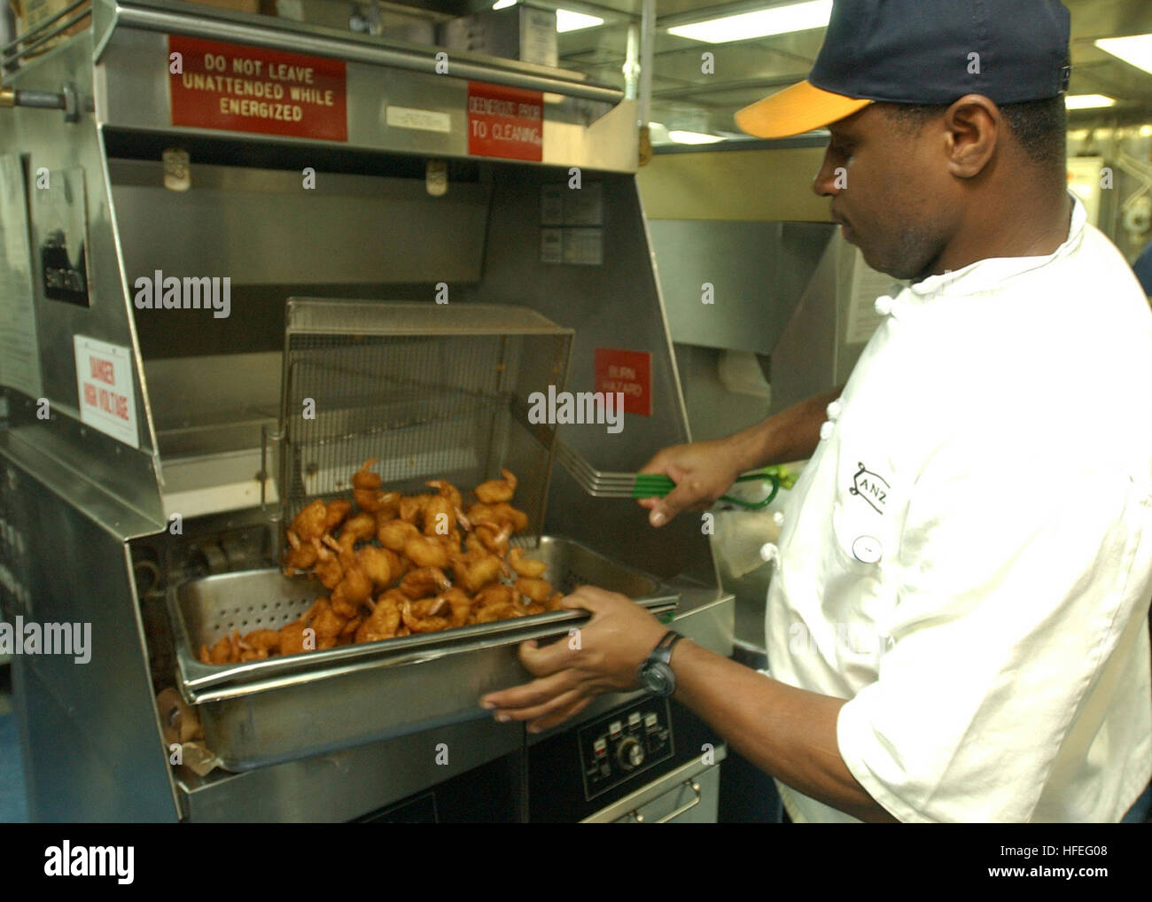 030224-N-6141B-158 The Mediterranean (Feb. 24, 2003) -- Mess Management Specialist 2nd Class Kenneth  Mayberry of Detroit, Mich., prepares butterfly fried shrimp in the galley aboard the guided missile cruiser USS Anzio (CG 68).  The Anzio is on a regularly scheduled deployment in support of Operation Enduring Freedom.  U.S. Navy photo by JOC Alan J. Baribeau.  (RELEASED) US Navy 030224-N-6141B-158 Mess Management Specialist 2nd Class Kenneth Mayberry of Detroit, Mich., prepares butterfly fried shrimp in the galley Stock Photo