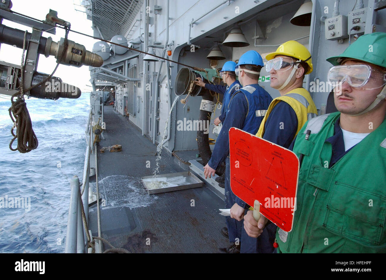 030329-N-3235P-505 Central Command Area of Responsibility (Mar. 29, 2003) --Crewmembers assigned to Refueling Station Seven aboard the guided missile cruiser USS Cape St. George (CG 71) give the signal to disengage the refueling probe during an underway replenishment (UNREP) with the Military Sealift Command fast combat support ship USNS Arctic (T-AOE 8).  Cape St. George and Arctic are deployed in support of Operation Iraqi Freedom, the multi-national coalition effort to liberate the Iraqi people, eliminate Iraq's weapons of mass destruction, and end the regime of Saddam Hussein.  U.S. Navy p Stock Photo