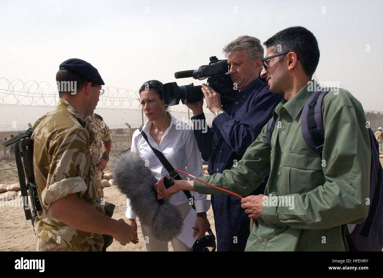 030331-N-5362A-012 Umm Qasr, Iraq (Mar. 31, 2003) -- A member of the British Royal Marines speaks to NBC's Today's show anchor Ann Curry about the recent arrival of water and food supplies by British and American troops at Iraq's southern port city of Umm Qasr.   Operation Iraqi Freedom is the multinational coalition effort to liberate the Iraqi people, eliminate Iraq's weapons of mass destruction and end the regime of Saddam Hussein.  U.S. Navy photo by Photographer's Mate 1st Class Arlo K. Abrahamson.  (RELEASED) US Navy 030331-N-5362A-012 A member of the British Royal Marines speaks to NBC' Stock Photo
