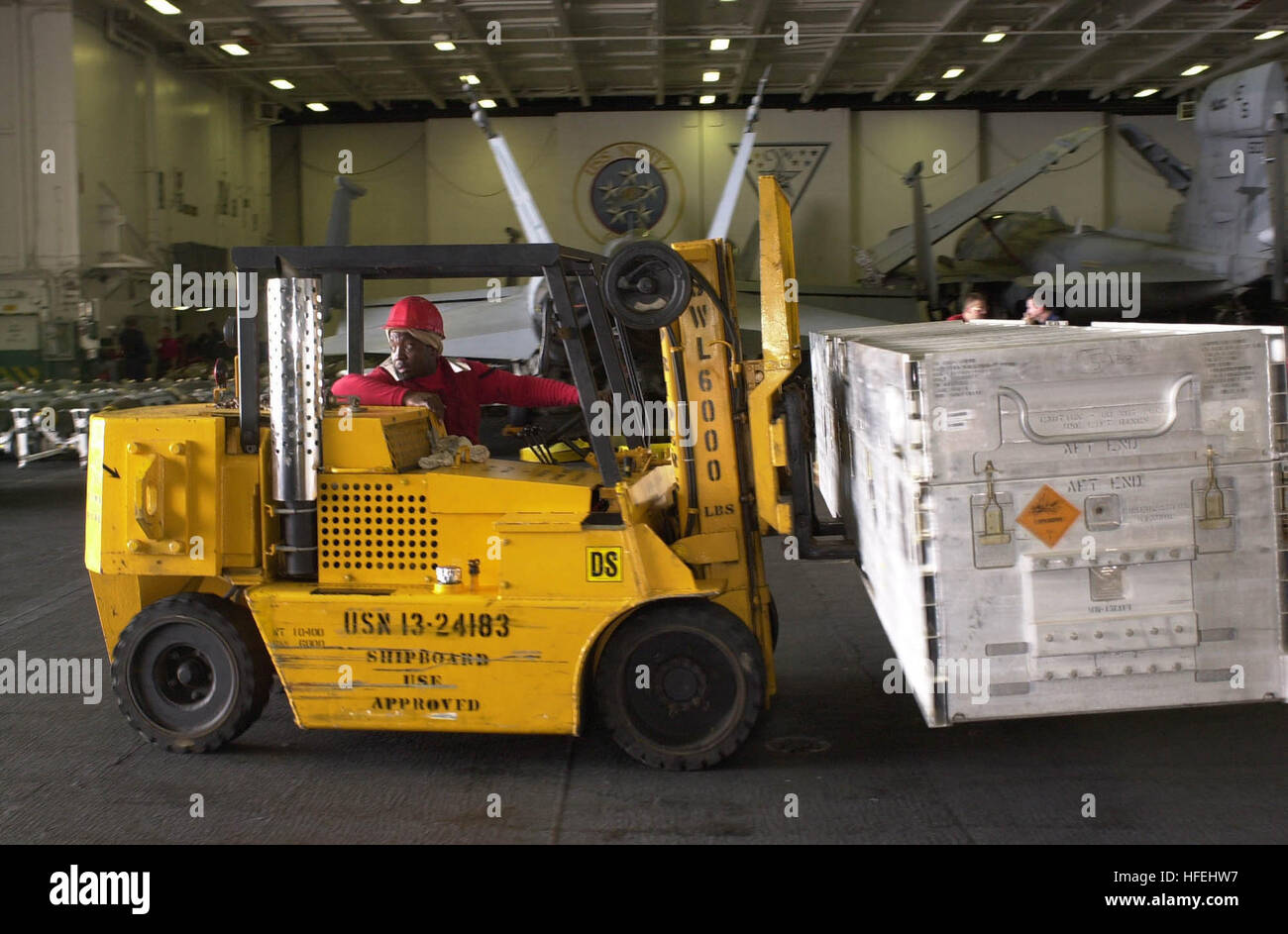 An Aviation Ordnanceman aboard USS Nimitz transfers ordnance containers ...