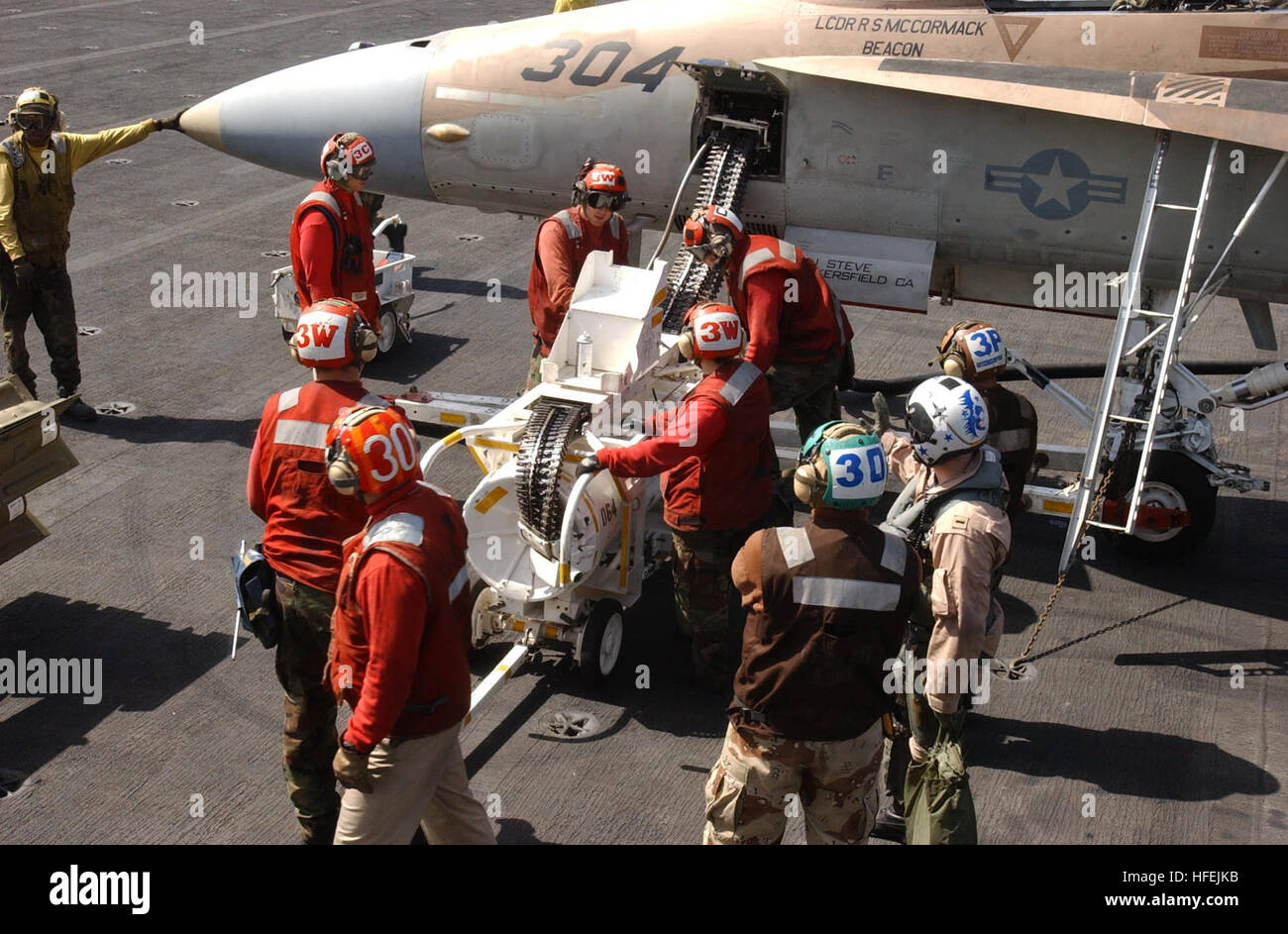 030417-N-4441P-003 Arabian Gulf (Apr. 17, 2002) -- Aviation Ordnancemen assigned to the ÒWarhawksÓ of Strike Fighter Squadron Nine Seven (VFA-97) reload 20mm bullets into the 20mm gun system (M61A1) on an F/A-18 Hornet during flight operations aboard USS Nimitz (CVN 68).  Nimitz and her embarked Carrier Air Wing Eleven (CVW-11) are on deployment conducting combat missions in support of Operation Iraqi Freedom.  Operation Iraqi Freedom is the multi-national coalition effort to liberate the Iraqi people, eliminate Iraq's weapons of mass destruction, and end the regime of Saddam Hussein.  U.S. Na Stock Photo