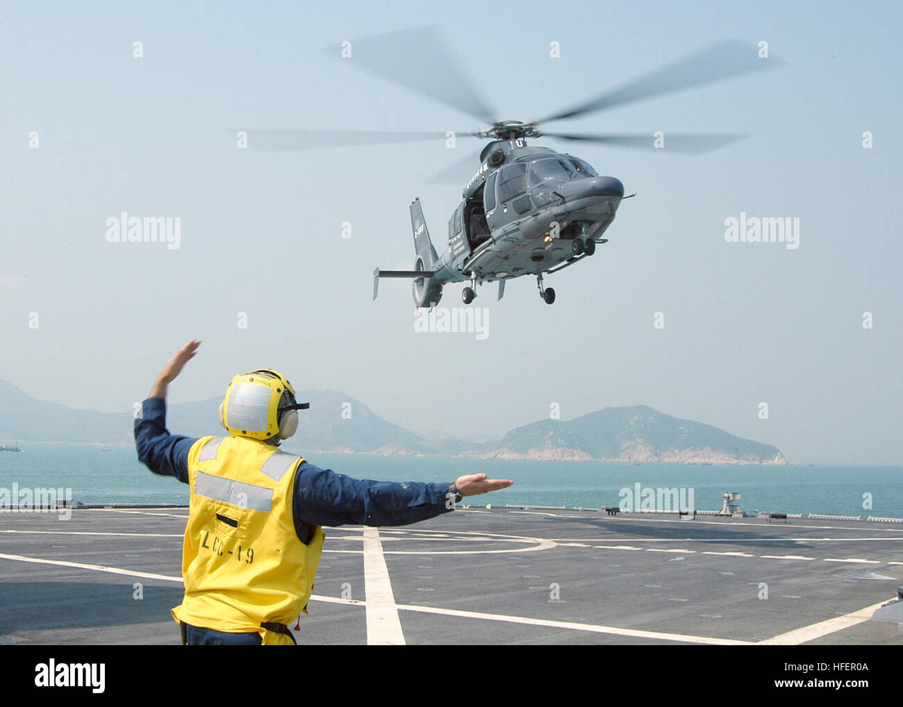 031101-N-8955H-002 Hong Kong (Nov. 1, 2003) -- Landing Signalman Enlisted (LSE) BoatswainÕs Mate 1st Class Joseph Mullen, from Seattle, Wash., signals an EC-155 Dauphin helicopter from the Hong Kong Government Flying Service to depart the ship's flight deck.  U.S. Navy photo by PhotographerÕs Mate 1st Class Novia E. Harrington.  (RELEASED) US Navy 031101-N-8955H-002 Landing Signalman Enlisted (LSE) Boatswain%%5Ersquo,s Mate 1st Class Joseph Mullen, from Seattle, Wash., signals an EC-155 Dauphin helicopter from the Hong Kong Government Flying Service to depart the sh Stock Photo