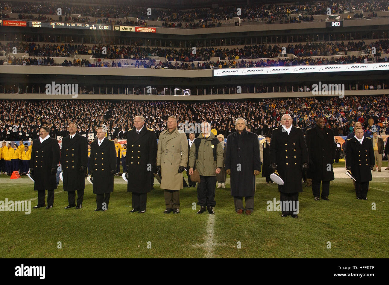 031206-N-2383B-182 Philadelphia, Pa. (Dec. 6, 2003) -- Senior leadership pays tribute to Army and Navy alma mater songs at the conclusion of the 104th meeting between the Army Black Knights and Navy Midshipmen.  From left to right are Master Chief Petty Officer of the Navy (MCPON) Terry Scott; CNO-Directed Command Master Chief William Nissen, U.S. Naval Academy; Capt. Charles Leidig, Commandant of Midshipmen, U.S. Naval Academy; Vice Adm. Rodney Rempt, Superintendent, U.S. Navy Academy; Gen. Michael W. Hagee, Commandant of the Marine Corps; the Honorable Gordon R. England, Secretary of the Nav Stock Photo