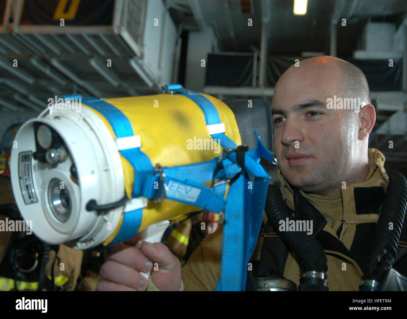 040106-N-7090S-003 Arabian Gulf (Jan 6, 2003) -- Damage Controlman 3rd Class Mike Milam from Dallas, Texas, looks through a Naval Firefighting Thermal Imager (NFTI) aboard USS Enterprise (CVN 65).  NFTI is a device that allows the user to see through dense smoke and steam by sensing the difference in infrared radiation given off by objects with a temperature difference of at least four degrees Fahrenheit.  The Enterprise Carrier Strike Group (CSG) is currently deployed conducting missions in support of Operation Iraqi Freedom and the continued war on terrorism.  U.S. Navy photo by Photographer Stock Photo