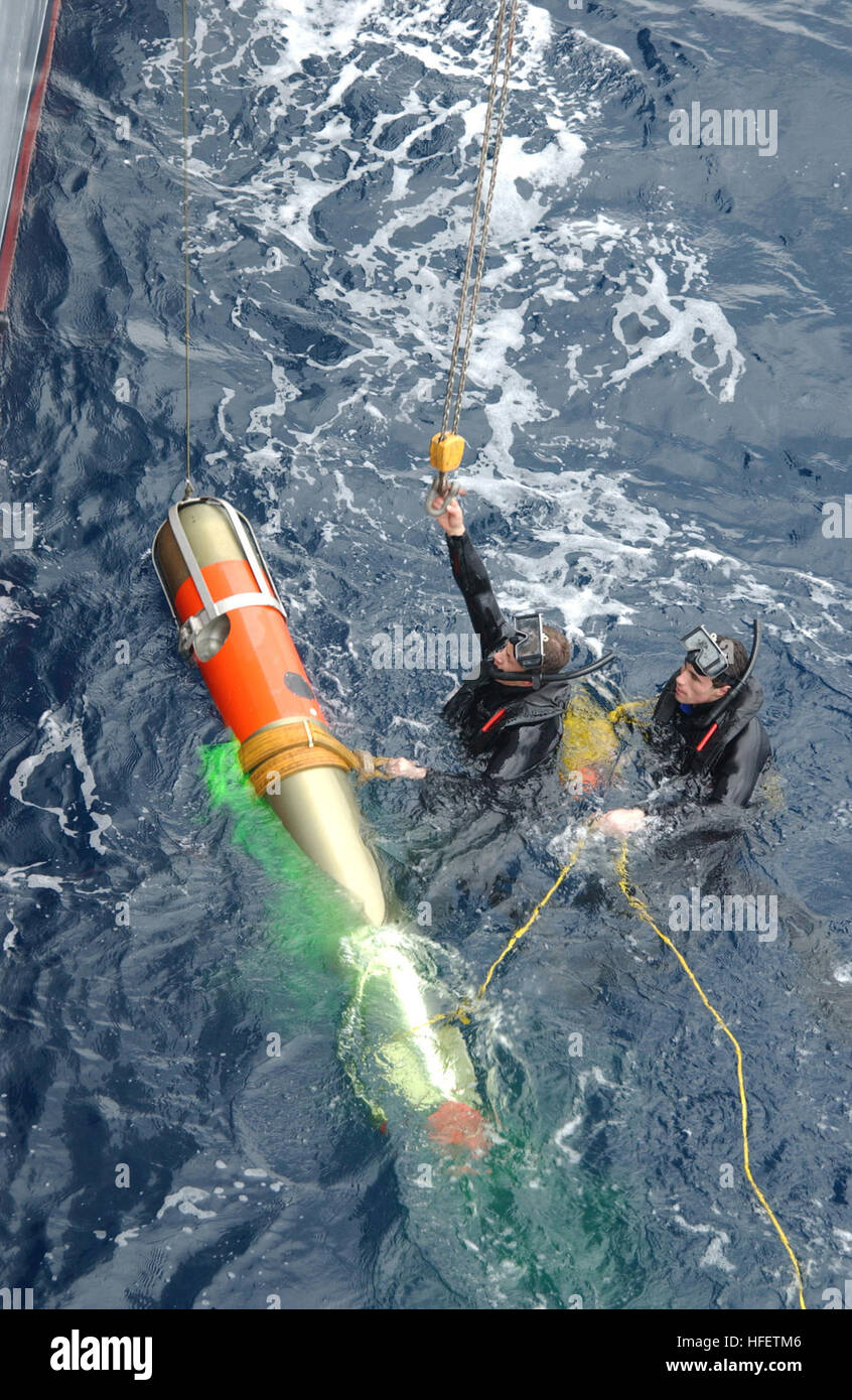 040129-N-9288T-087 Pacific Ocean (Jan. 29, 2004) – Search and rescue swimmers Quartermaster 2nd Class Justin Peel, from Polson, Mont., and Sonar Technician Surface 2nd Class Stephen Stavros, from Springtown, Mass., secure an MK-46 exercise torpedo to be hoisted aboard the guided missile cruiser USS Vincennes (CG 49) after a successful torpedo exercise.  Vincennes is participating in Multi-Sail, a combat readiness exercise in the Okinawa operational area.  It’s designed to complete Surface Force Training Manual Requirements and to exercise participants in a multi-ship operational environment.   Stock Photo