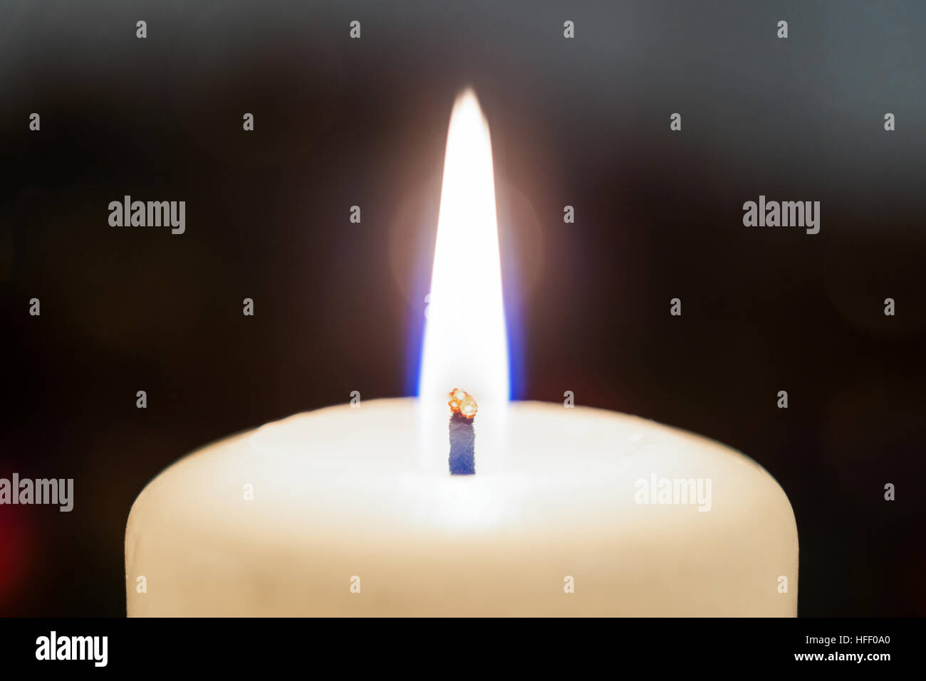 Closeup of a white burning candle Stock Photo - Alamy