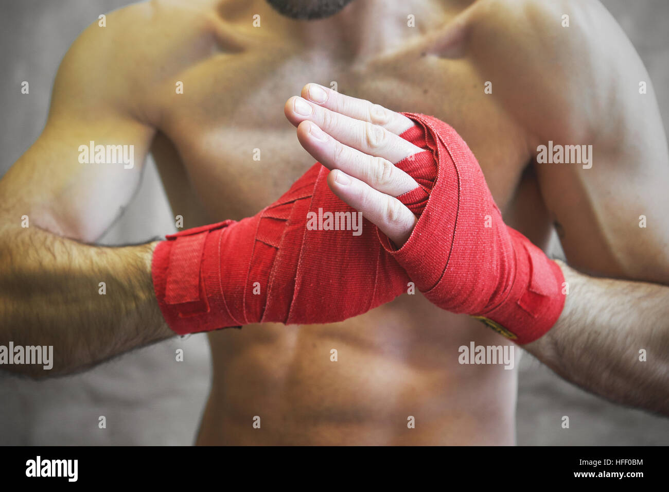 Shot of wrapped hands with red boxing tape of young boxer fighter Stock