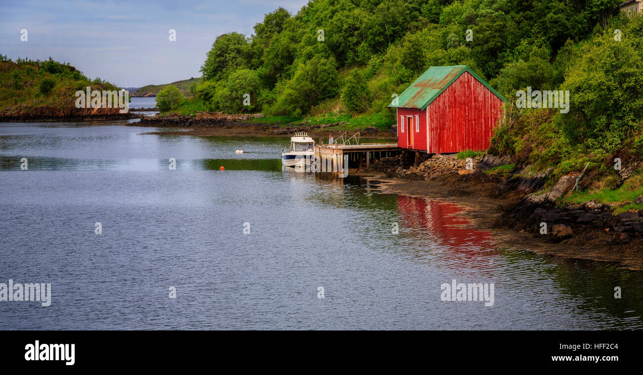 Red building and wharf with boat at Vevang, Norway Stock Photo