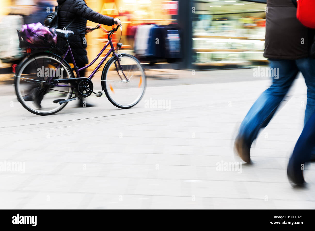 people walking and cycling in the city with camera made motion blur ...