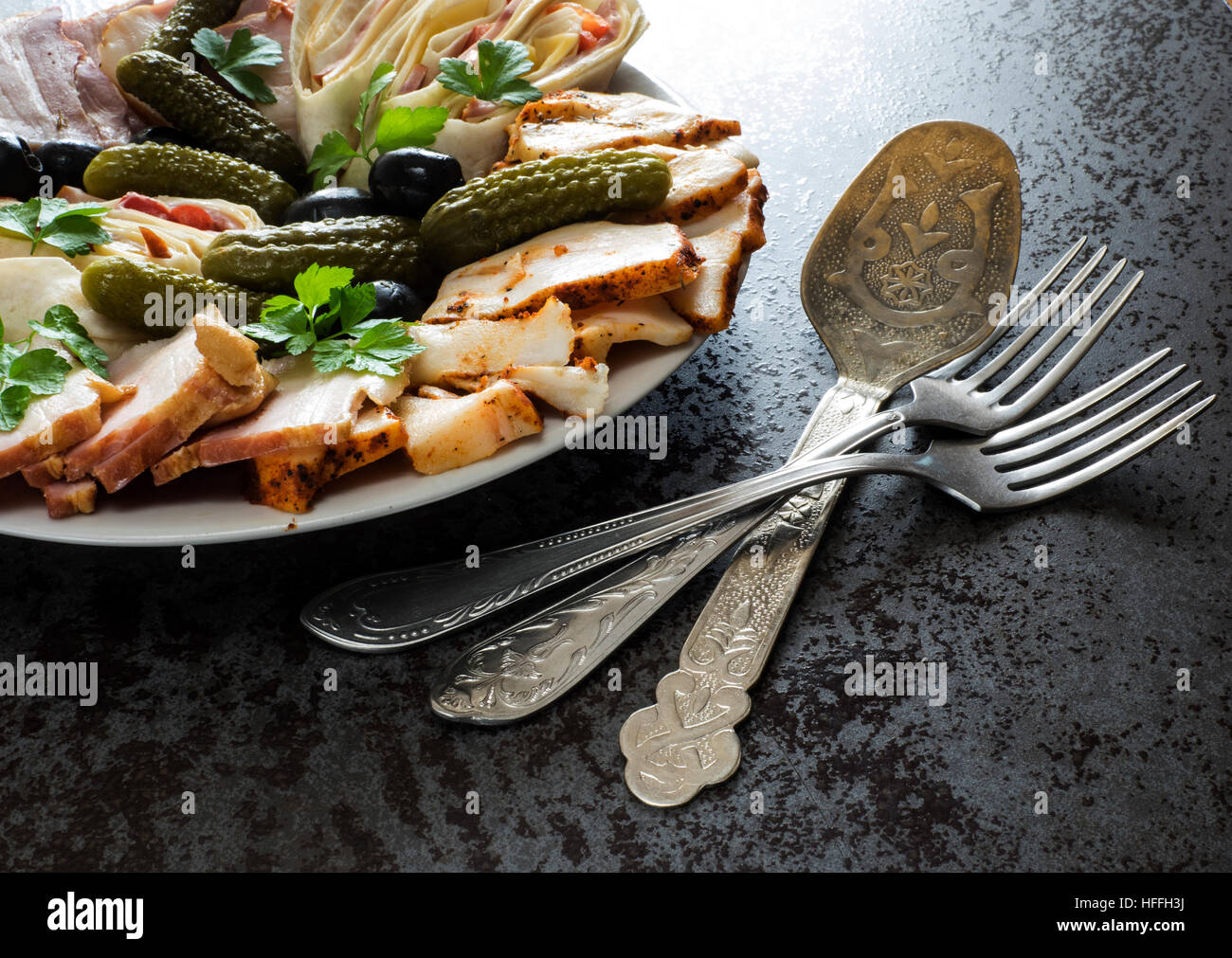 Plate of cold meats with ham, bacon, olives and pickles Stock Photo