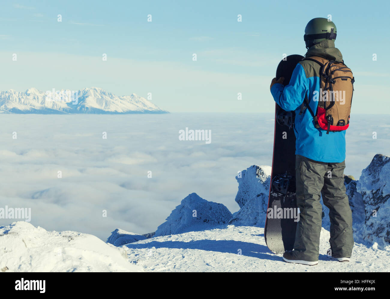 Man holding snowboard and taking a look at landscape at the top of the ...