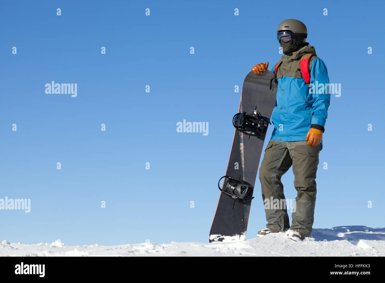 Man holding snowboard and taking a look at landscape at the top of ...
