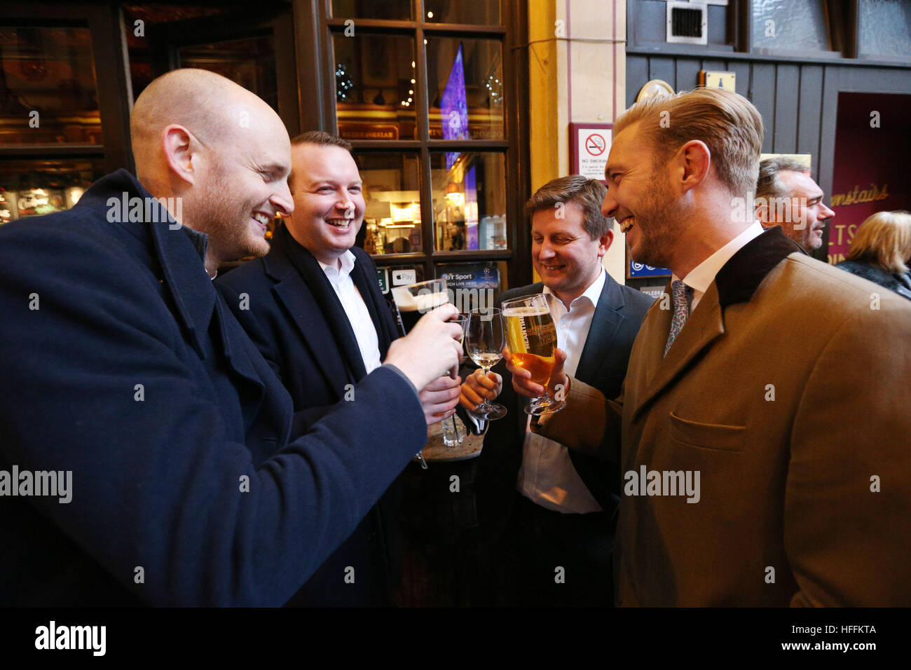 City workers (no names available) celebrate at the New Moon public house in Leadenhall Market, in the financial district of London, after the FTSE 100 index surged to an all-time high and recorded its best year since 2013. Stock Photo