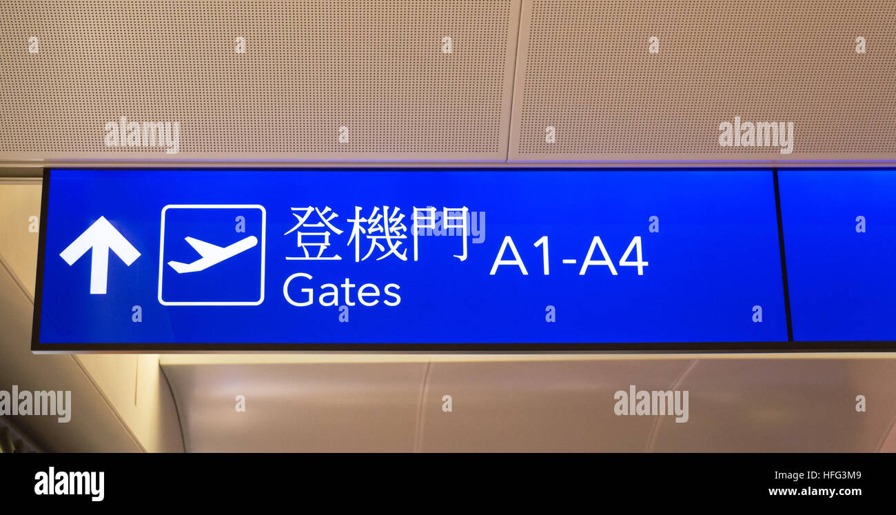 Blue illuminated sign with gate numbers for departing flights with traditional Chinese characters Stock Photo