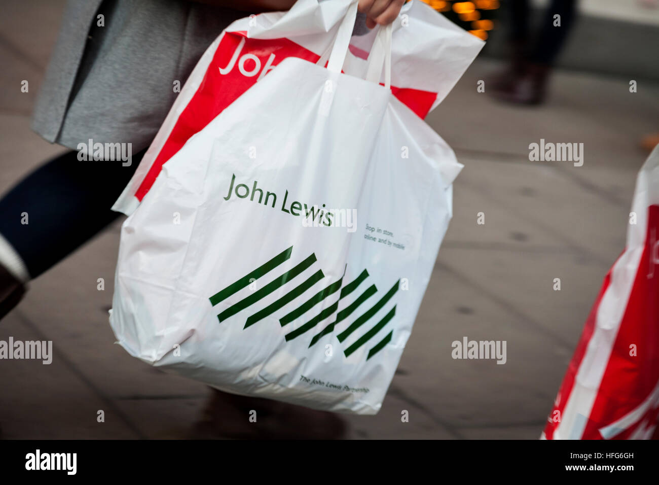 Young female shopper carries John Lewis shopping bags on Oxford Street ...