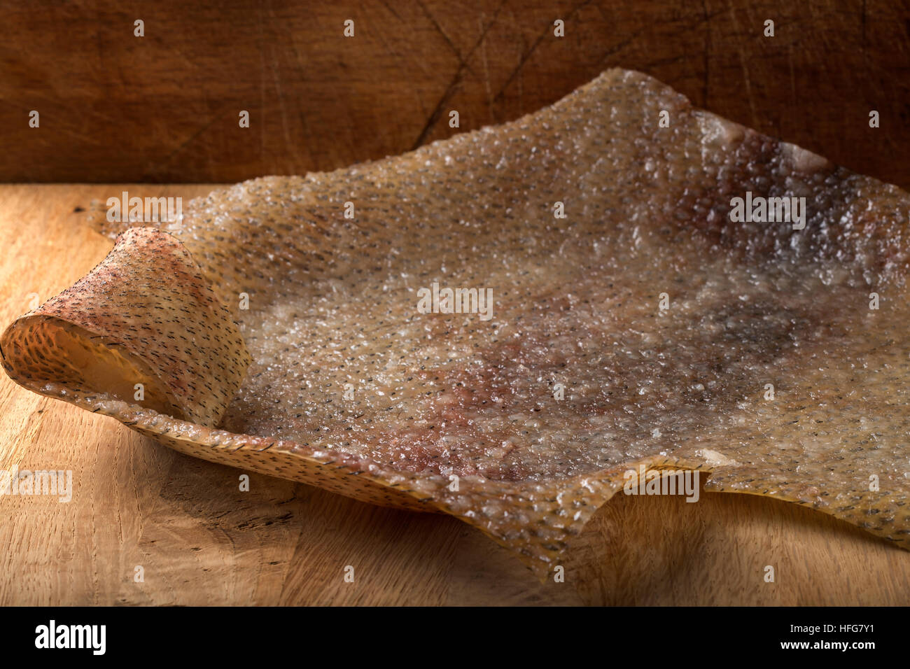 Close up of smoked pork skin (Romanian traditional food - soric) on a wooden background Stock Photo