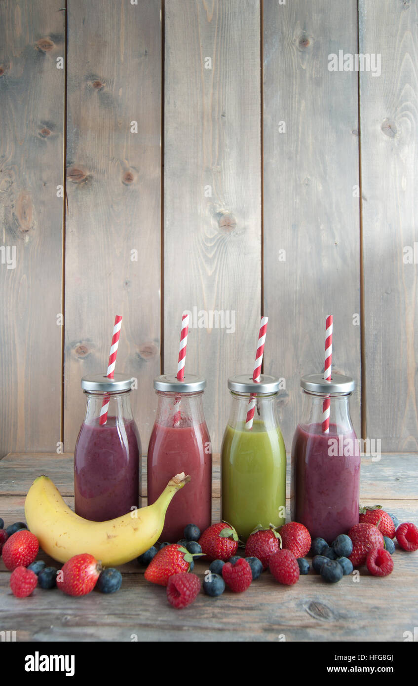 https://c8.alamy.com/comp/HFG8GJ/flavoured-smoothies-in-bottles-in-a-rack-over-a-wooden-background-HFG8GJ.jpg