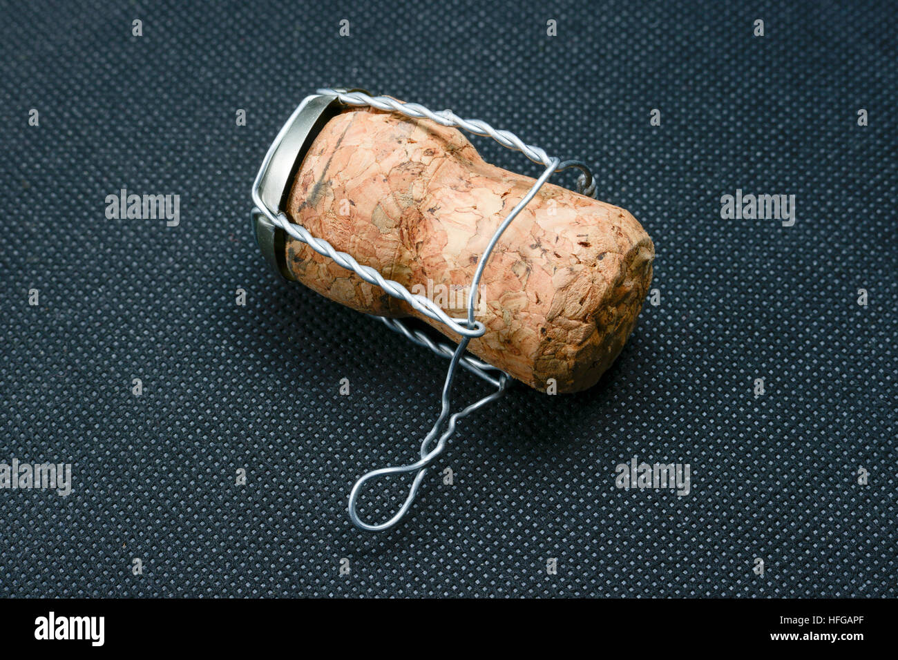 detailed champagne cork on black perforated material background Stock Photo