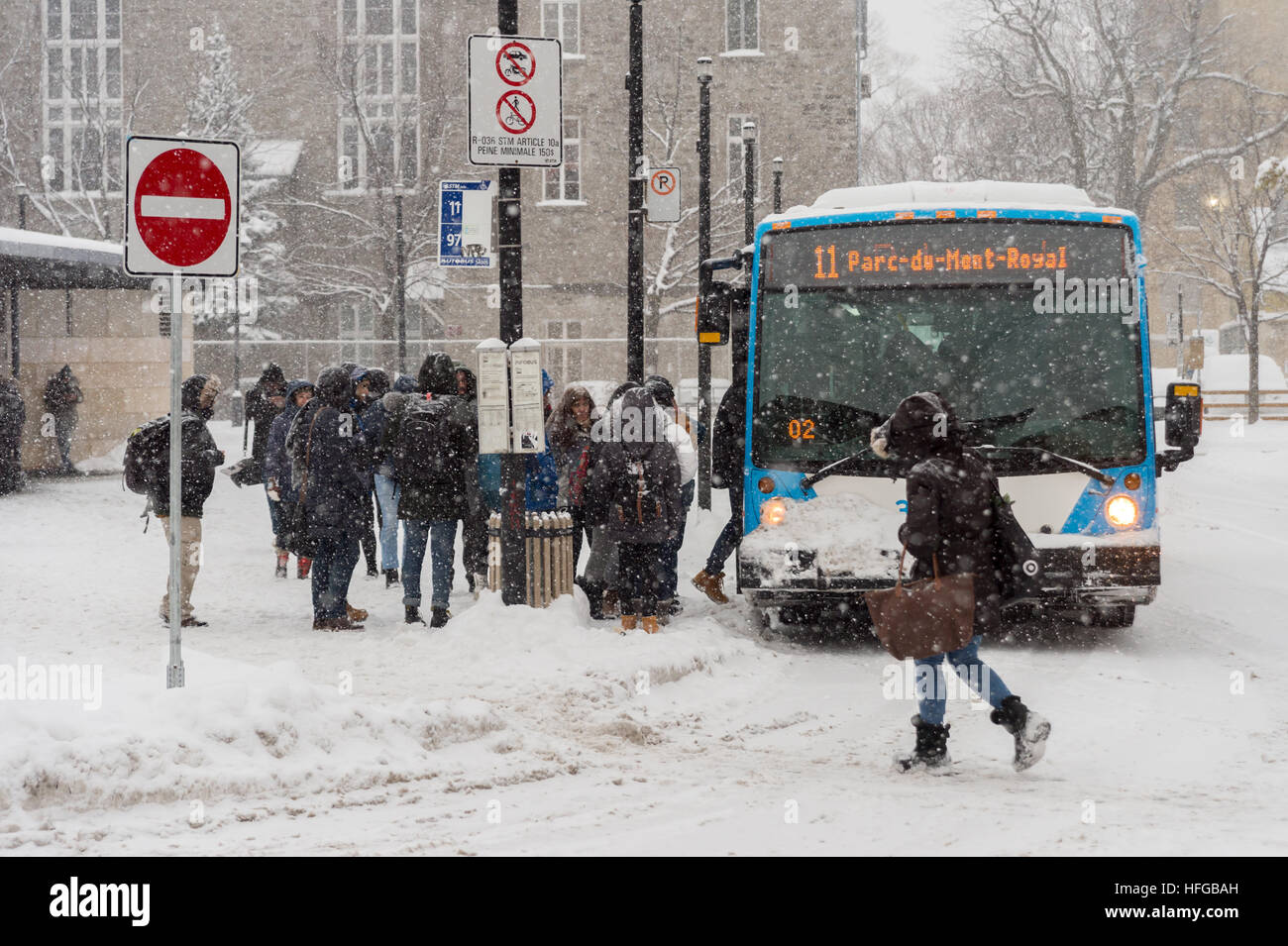 Montreal, CA - 12 December 2016: Commuters boarding a STM bus during snow storm. Stock Photo