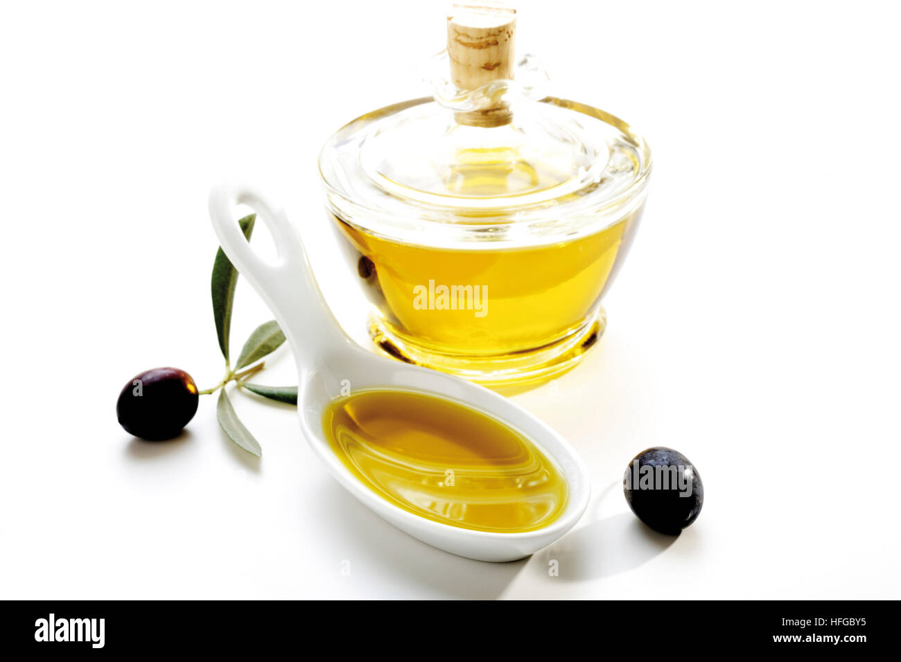 Porcelain spoon with olive oil, olives and olive oil bottle Stock Photo ...